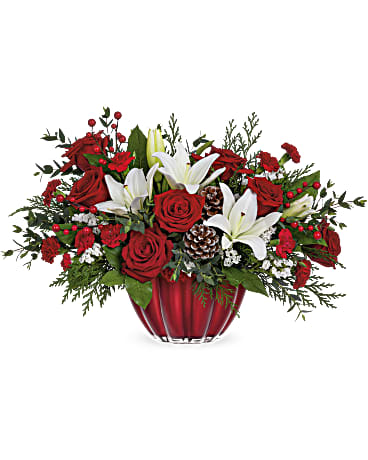 Teleflora's Vibrant Christmas Centerpiece - Dress up your holiday celebrations with this elegant Christmas rose bouquet. Filled with red roses, white asiatic lilies, and miniature red carnations, this vibrant Christmas flower centerpiece is delivered in a beautifully arranged scalloped glass keepsake bowl with shimmering metallic finish. This Christmas flower bouquet features red roses, white lilies, miniature red carnations, white sinuata statice, cedar, parvifolia eucalyptus and lemon leaf. Delivered in Teleflora's Vibrant Christmas Bowl.