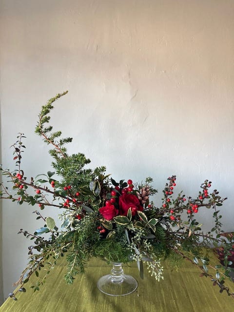 Christmas Compote Arrangement - A formally elegant arrangement of evergreens, berries and red roses to add dramatic beauty to your holiday table setting.