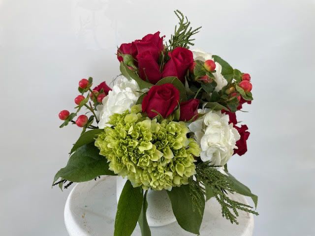 Holiday Thoughts - If someone is in your thoughts especially at the holidays, send this bouquet to let them know! Starting with a white ceramic container filled with florals in reds and greens, this piece is a fantastic choice to put a little holiday cheer on a bedside or coffee table.  The deluxe and premium size could be used as a centerpiece! Berries and greenery say, “You’re in my thoughts this holiday!”