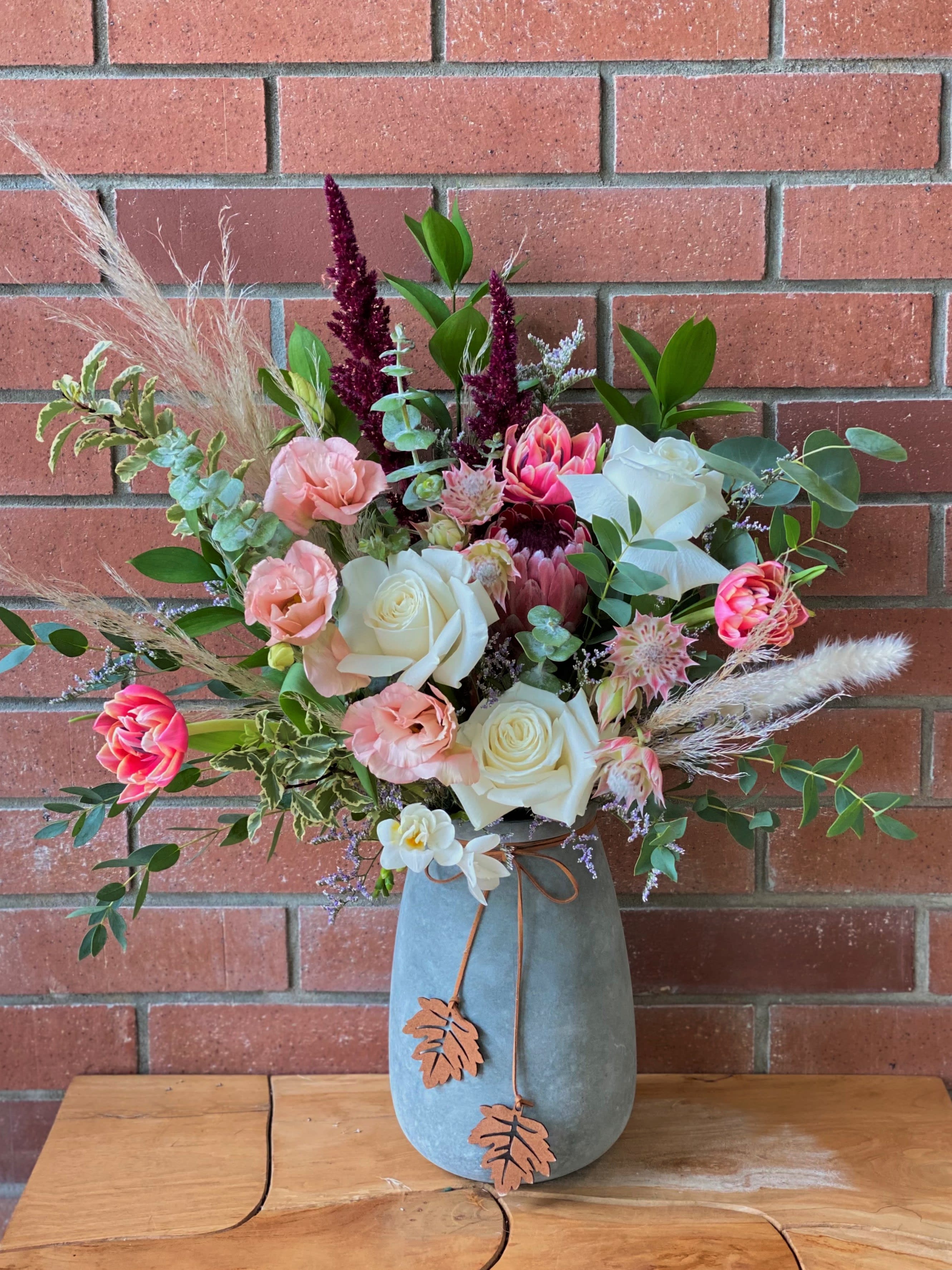 Soft Serenade Bouquet - That soft cozy chilled feeling you have when the season is changing is what this bouquet wil draw out of anyone this season with this lovely arrangment full of dry florals along with garden  roses, tulips,  freesia, amaranthus, protea, lisianthus, blushing bride and beautifully scented eucalyptus in 9' vase with suede tie &amp; leaf attachment.