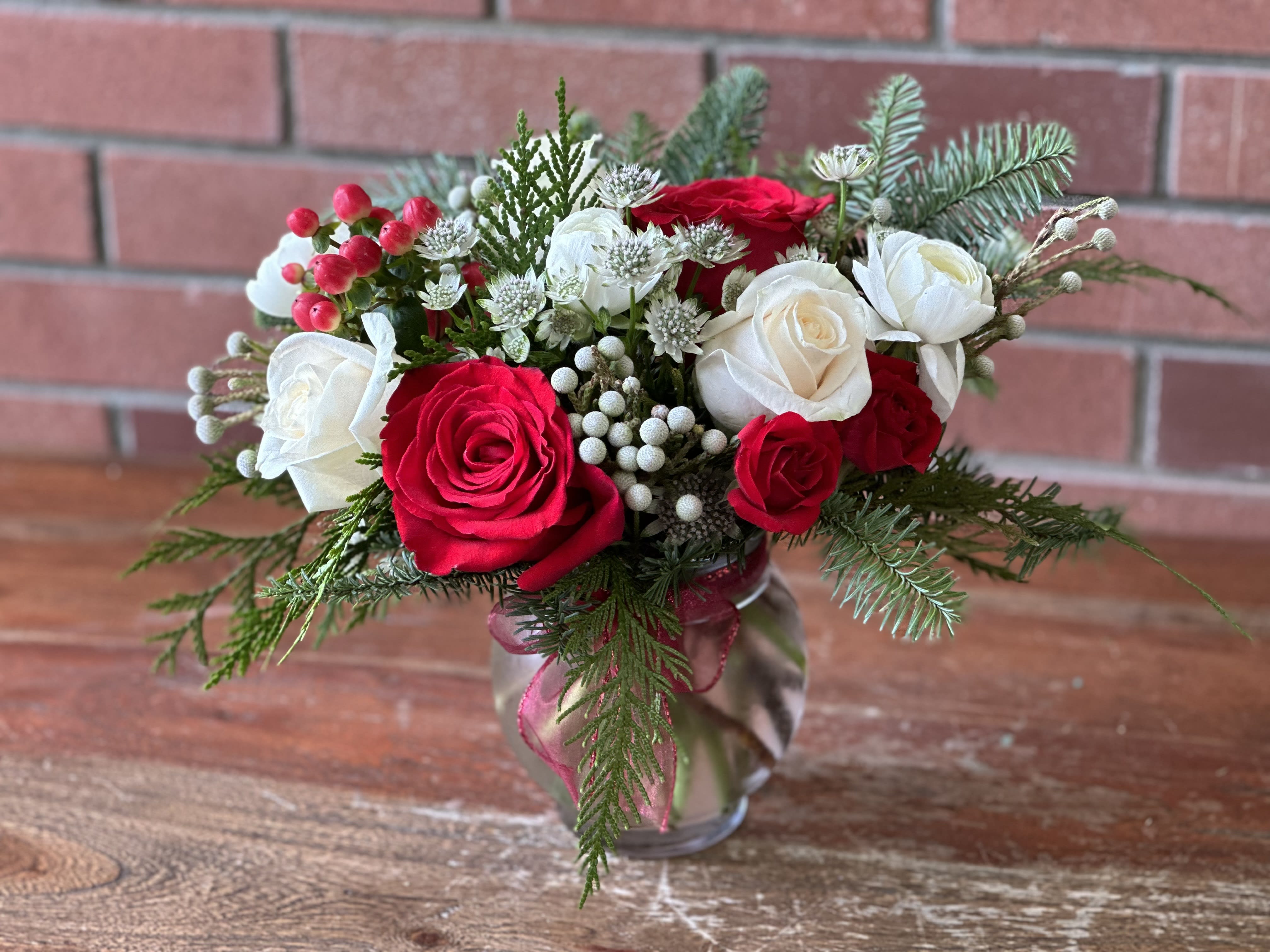 Winter Blooming Bowl  - Bubble bowl filled with beautiful evergreens, red and white roses , touches of white ranunculus, silver bruins and filler flower.