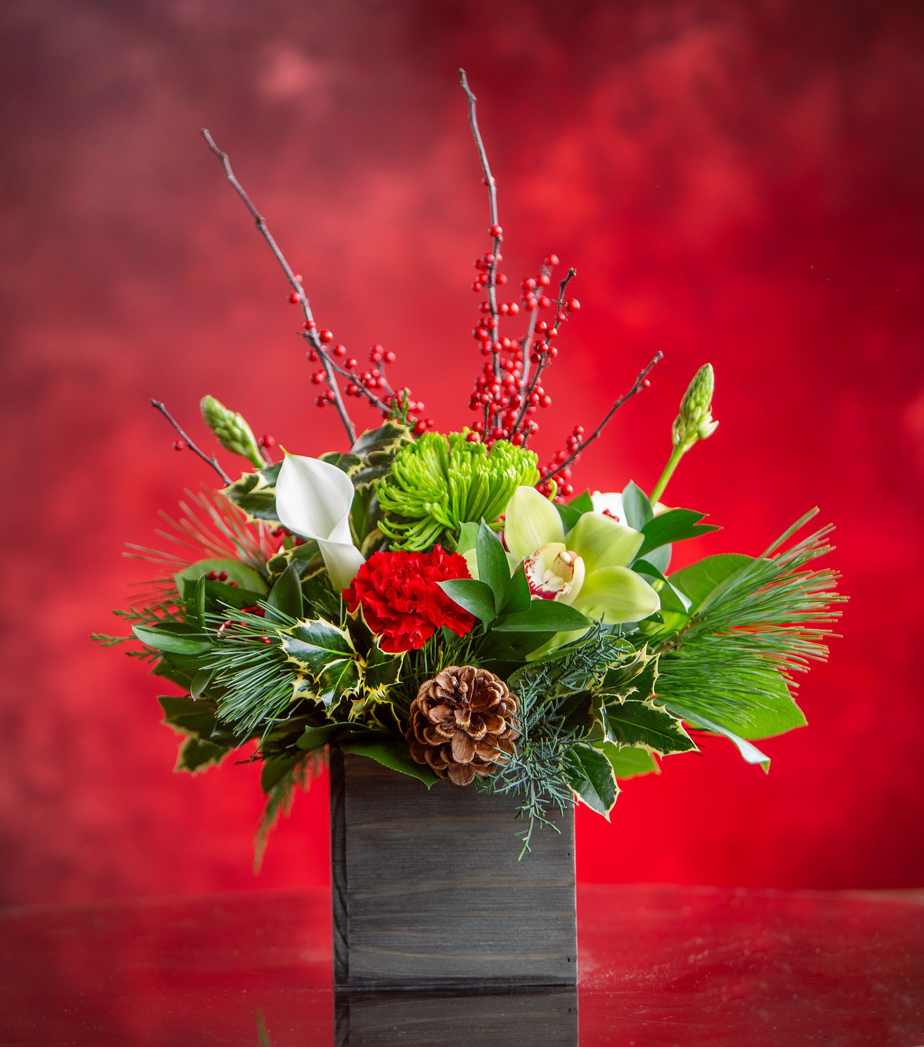 Christmas at the Cabin (sm) - A woodsy Christmas centerpiece that would look great on anyone's table, calla lilies, orchids, berries and more! Designed in a twig container and delivered by us, a real Portland florist to anywhere in the greater Portland Oregon area. Place your order online, or call us directly 503 223 1646