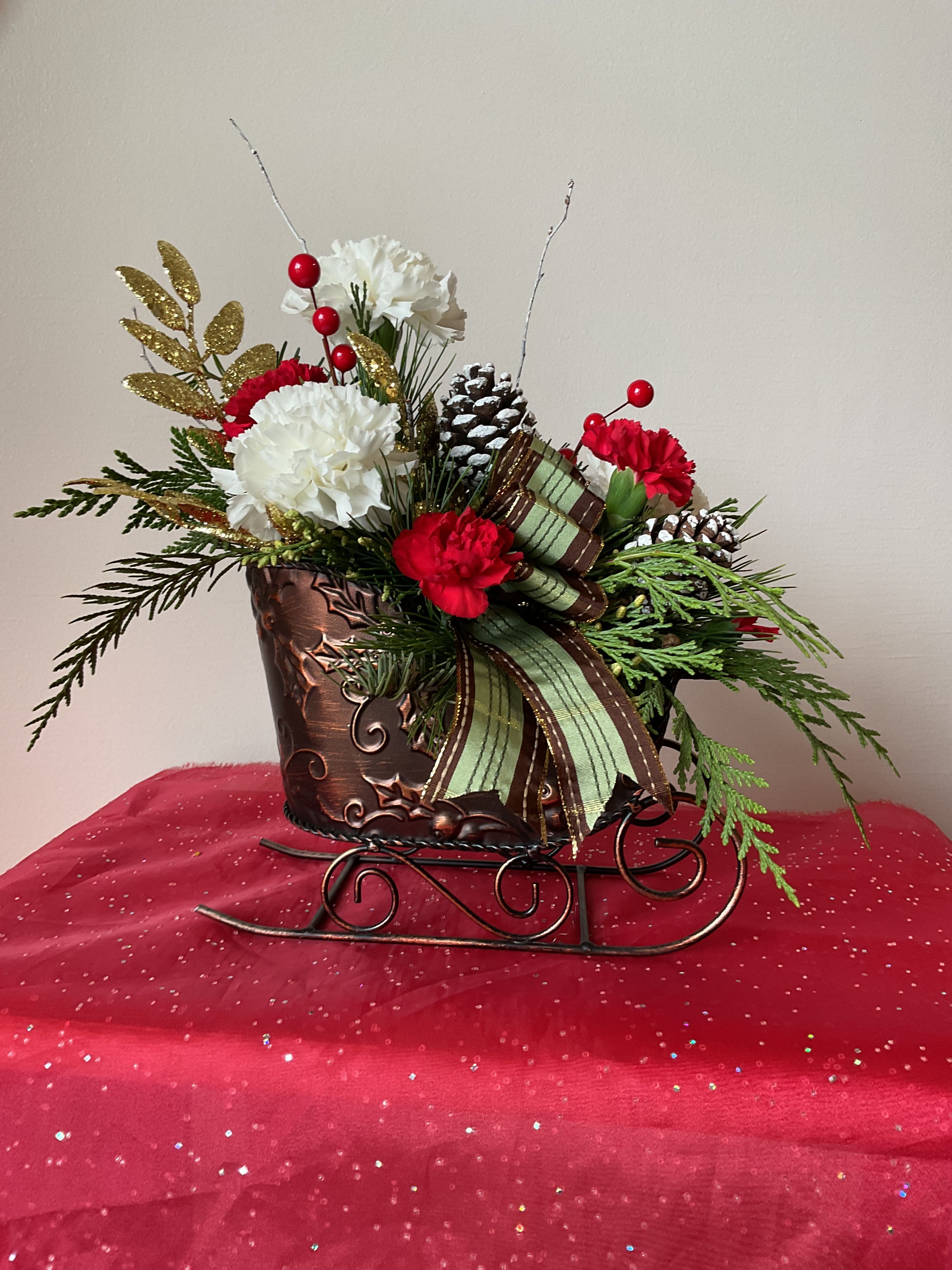 Sleigh Ride - A beautiful Christmas Arrangement in a sleigh to bring back fun childhood memories. 