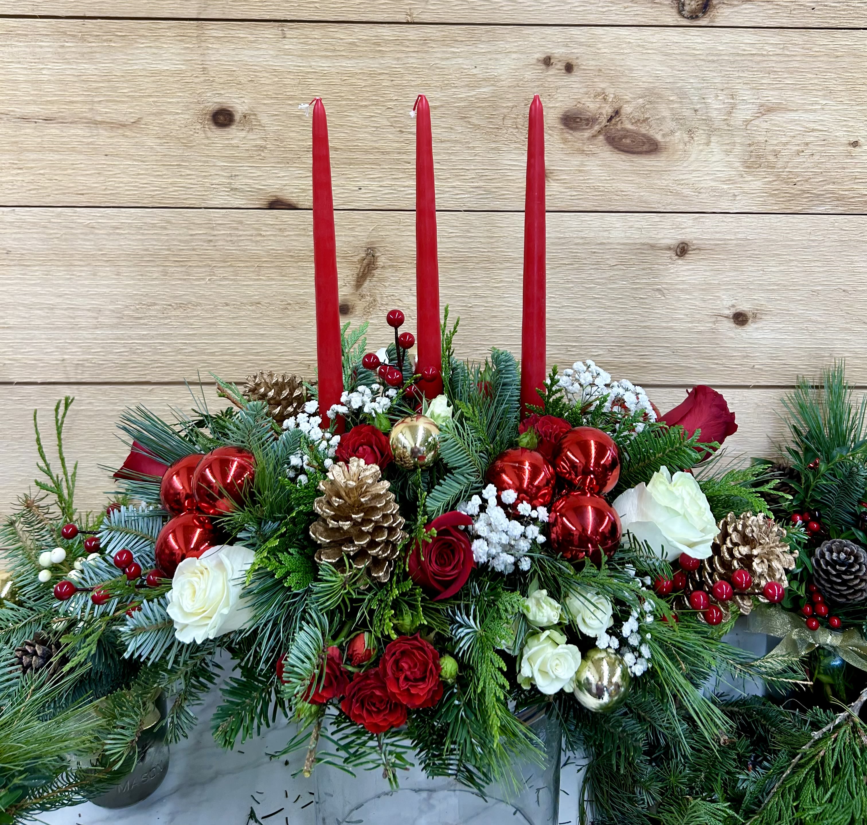 Traditional  christmas centerpiece - 3 candle oblong with mixed christmas green and red and white flowers , pinecones and Christmas balls