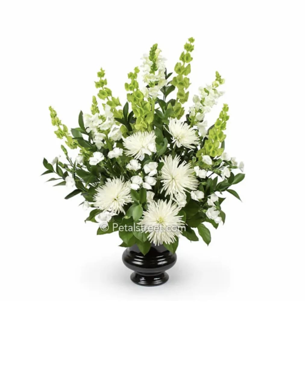 White Arrangement  - Graceful and calming, this all-white arrangement is designed to bring peace, comfort, and quiet beauty to any space. Soft white mums, snapdragons, and delicate accent blooms rise elegantly from lush green foliage, creating a soothing silhouette that feels both uplifting and serene.  Arranged in a classic vase, the design offers height, purity, and balance- a gentle expression of support during difficult times or a refined way to honor a loved one's memory. Its clean lines and peaceful palette make it suitable for services, home display, or a heartfelt gesture of sympathy and remembrance. Thoughtful, timeless, and deeply comforting, this arrangement speaks with grace when words are not enough. 