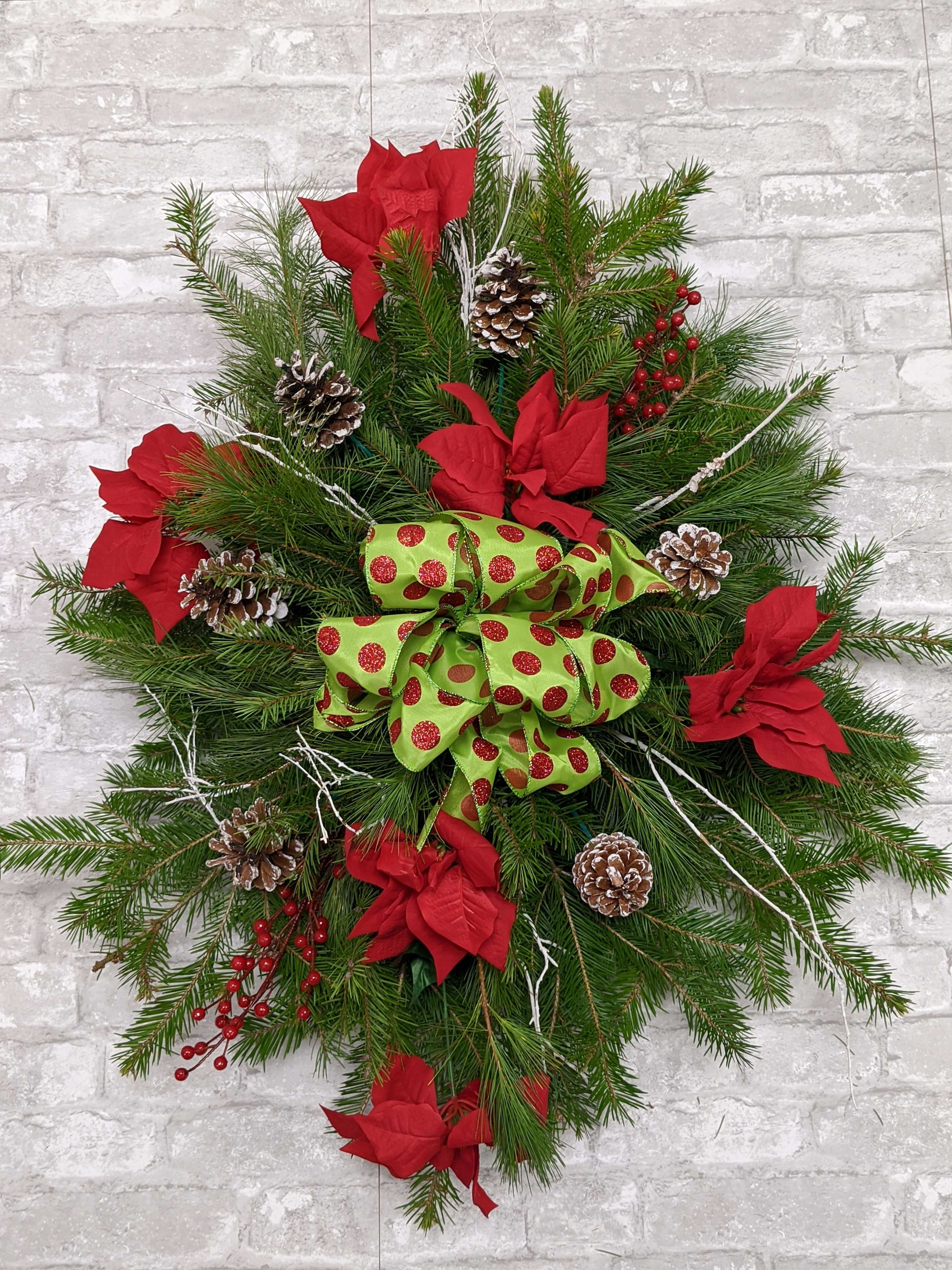 Medium Grave Spray - Our most popular is the medium grave spray consisting of various Christmas greens, pine cones, red velvet bow and frosted branches.  This lovely piece can be delivered to a local cemetery or picked up at the the store so you may honor your loved one personally.   Approximately 30&quot; long X 20&quot; wide. 