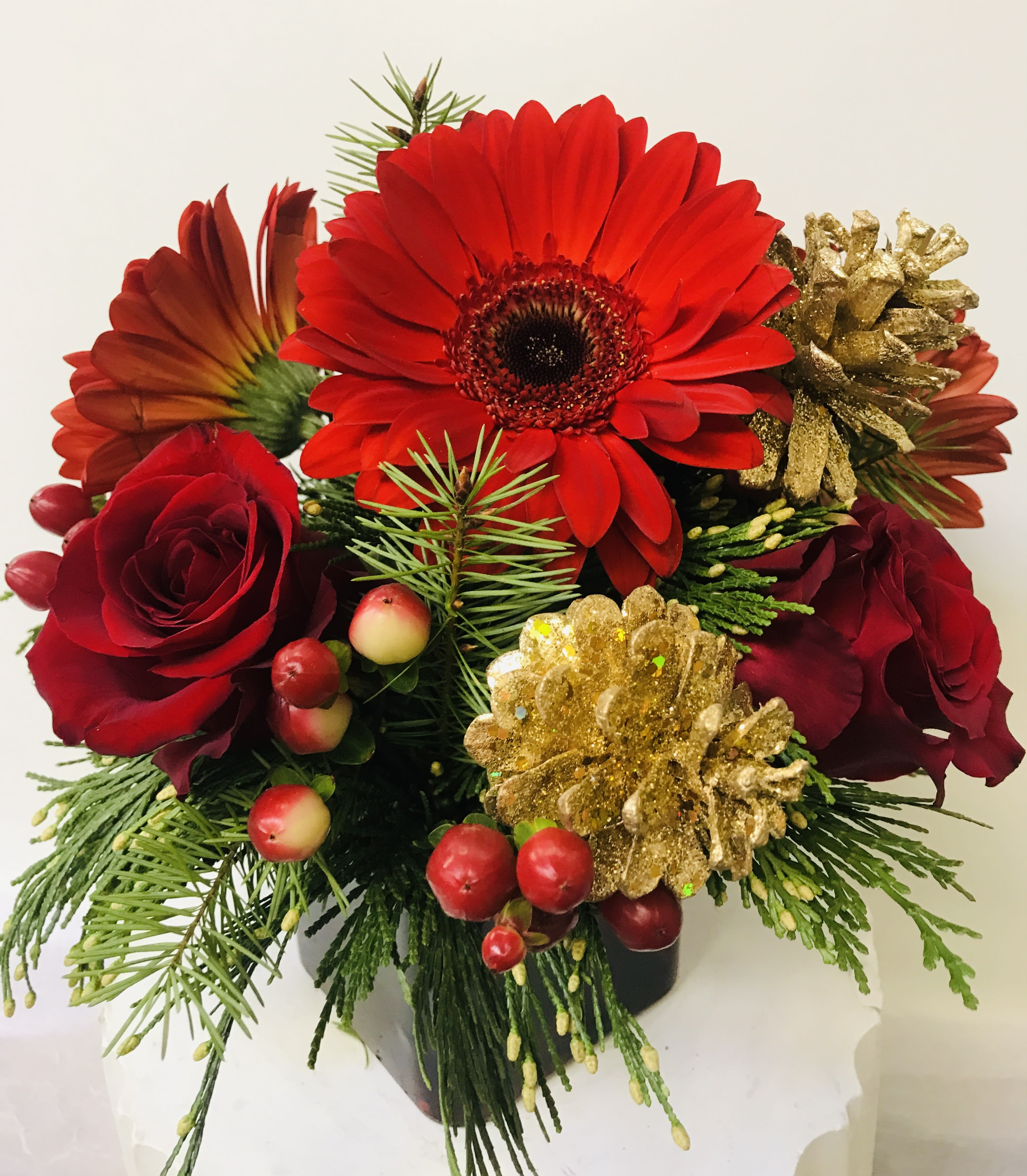 The Best Man Holiday  - red glass vase with a Xmas greenery red Gerber, red roses and gold cones 