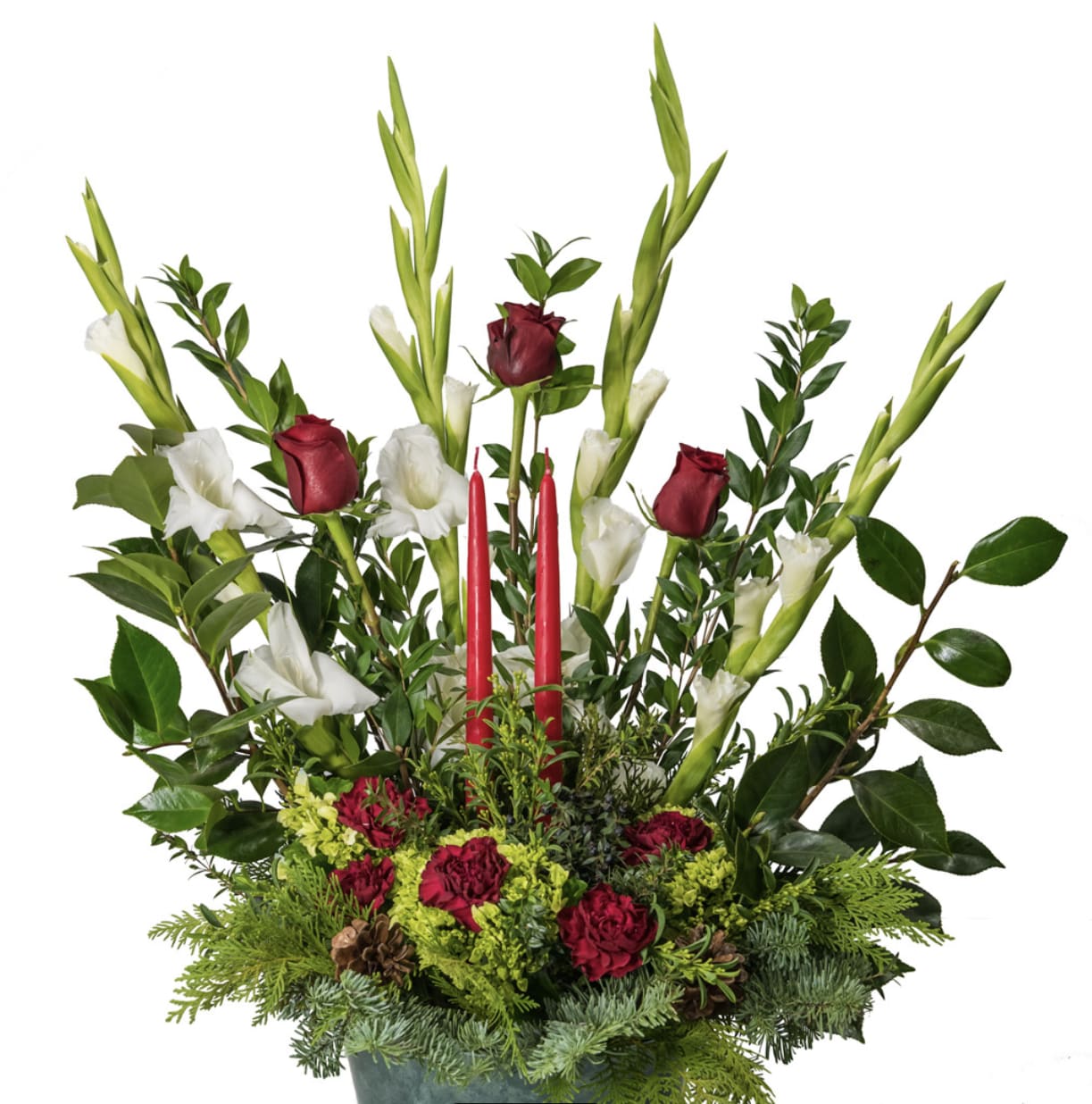 Winter Centerpiece - Bring the drama and beauty of the season to life with this stunning tall holiday arrangement. Rich red roses, elegant white gladiolus, and deep red carnations rise gracefully among lush winter evergreens and glossy Christmas foliage, creating a bold and sophisticated silhouette. Two classic red taper candles highlight the center, adding warmth, glow, and sense of festive tradition. The arrangement height and structure make it perfect for entry tables, buffet displays, mantle decor, or as a commanding centerpiece for holiday gatherings.  A luxurious blend of color, texture, and seasonal greenery, this design captures the true spirit of Christmas- elegant, warm, and joyfully timeless.