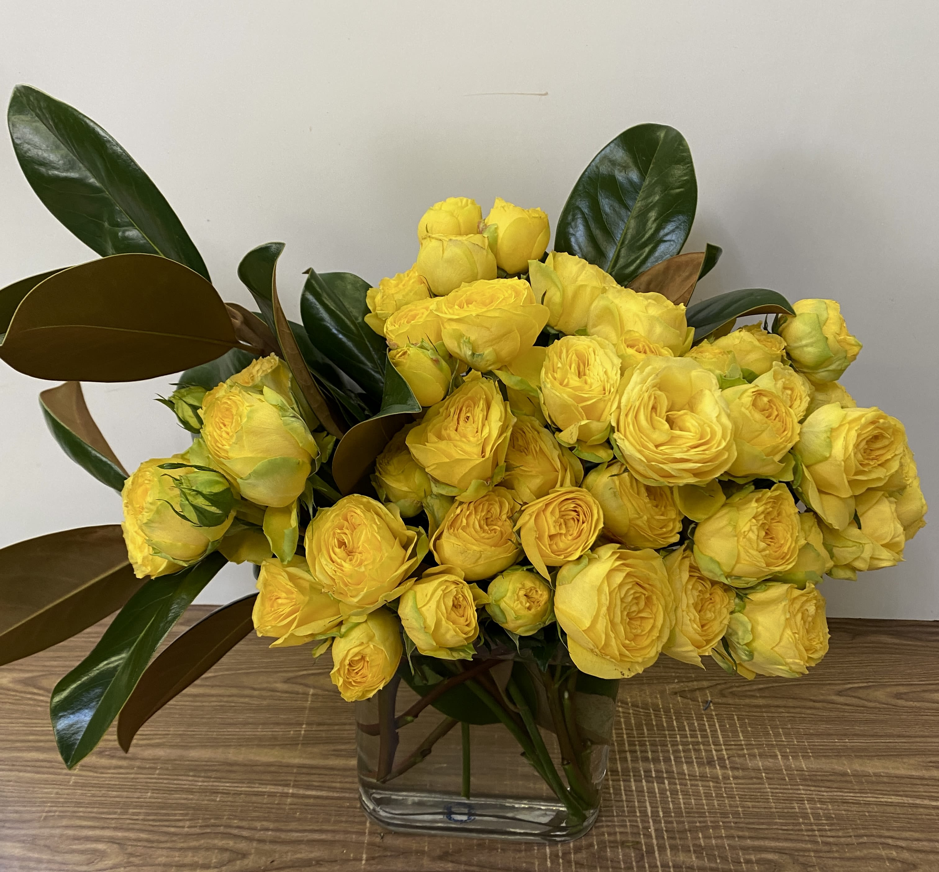 Wrong Paris - In a glass vase combination of Garden yellow roses with magnolia leaves