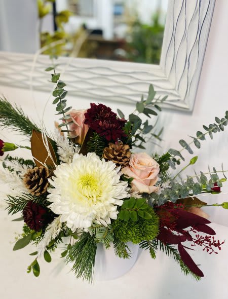 Holiday Luxe - A modern holiday design featuring white, blush, and burgundy blooms arranged with fresh scented pine and rustic accents.   