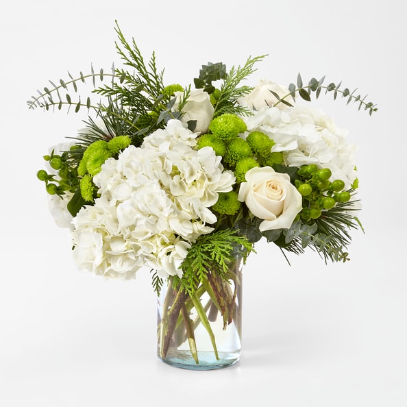 Winter Bliss Bouquet - This monochromatic beauty glistens just like the first snow and adds freshness to any celebration. It comes arranged with roses, hydrangea and accents of pine &amp; cedar winter greens.