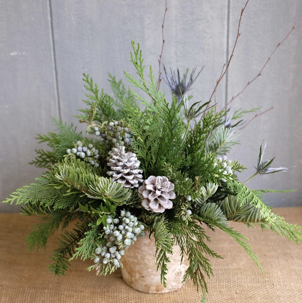 White Christmas  -  A beautiful arrangement of Christmas greenery with white pinecones and birch branches. 