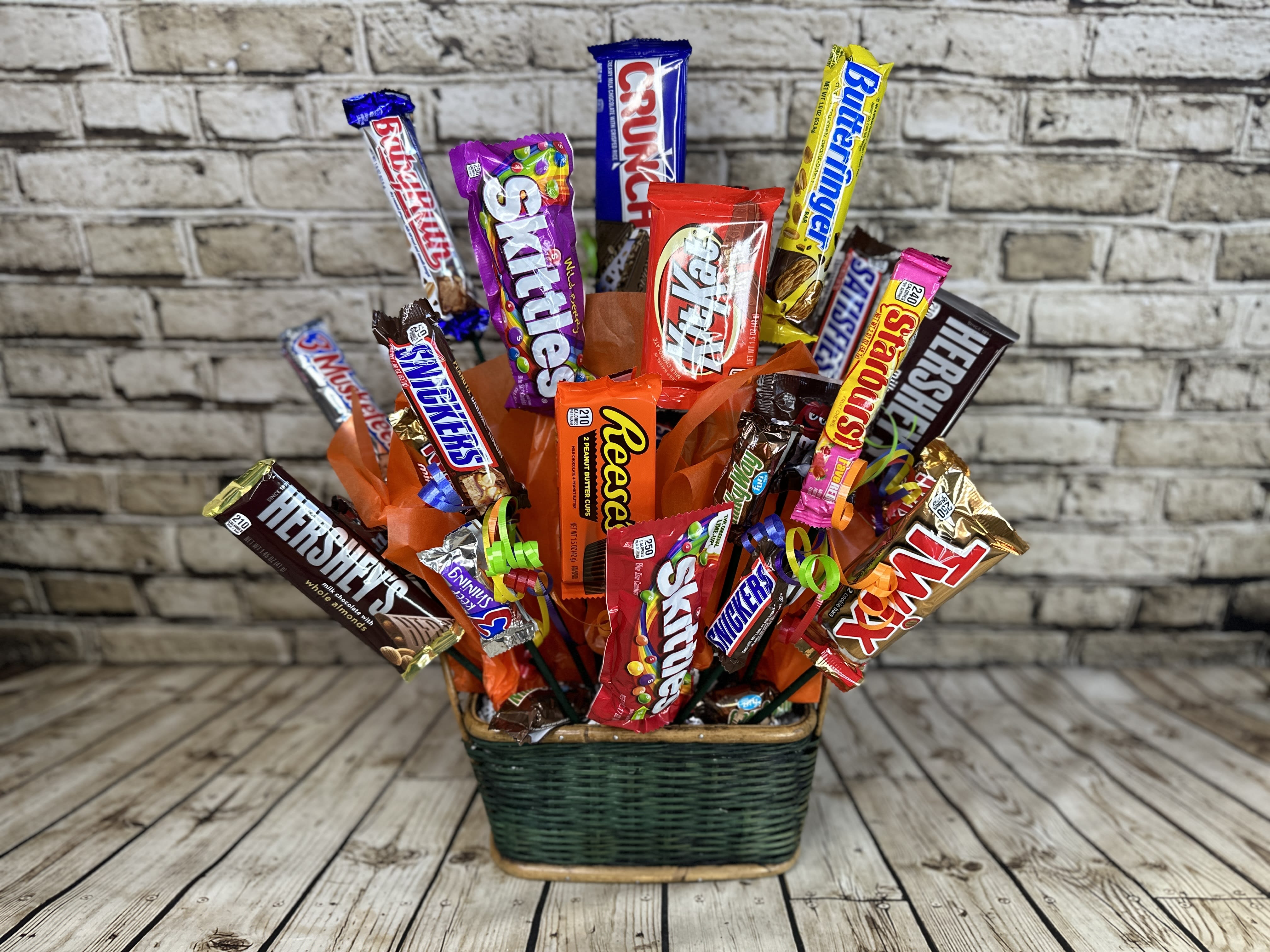 Candy Bouquet - Deluxe - This delightful candy bouquet is a playful fusion of color and sweetness, featuring an assortment of vibrant candies and treats artfully arranged in a whimsical bouquet design. Each candy bouquet creates a fun and festive display that’s perfect for birthdays, celebrations, or simply to brighten someone's day. It’s a delightful treat for the eyes and the taste buds!   Approximately 25 pieces per bouquet. Candy varieties may vary from photo depending on availability.  Candy Bouquet will be delivered wrapped in clear cellophane and ribbon to add that festive touch