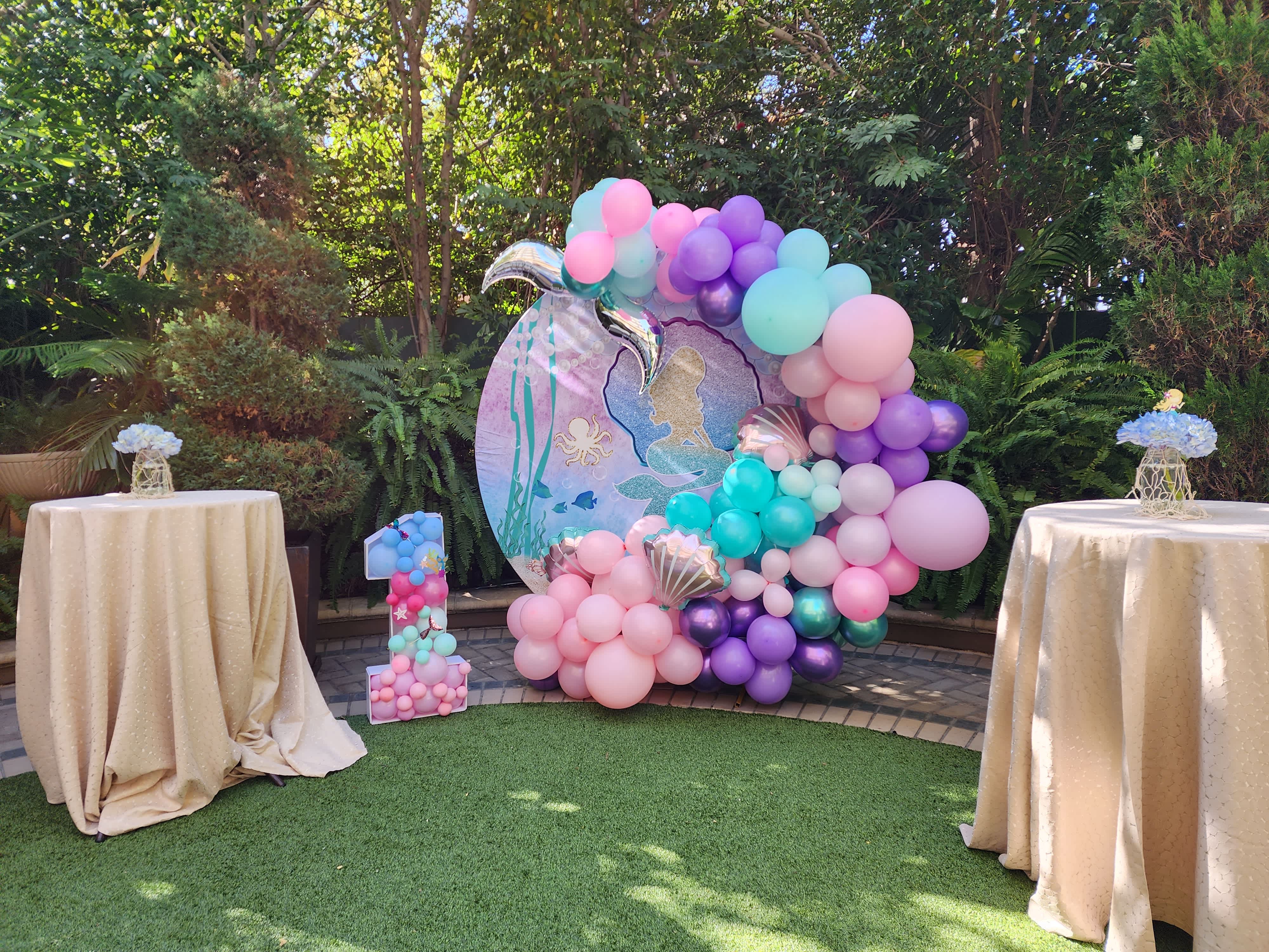 Mermaid-Style Balloon Arch - Dive into enchantment with our Mermaid-Style Balloon Arch. This stunning display features a captivating mix of iridescent, pastel, and ocean-inspired balloons, creating a magical underwater scene. Perfect for birthdays, themed parties, or any event seeking a touch of fantasy, this arch captures the essence of the ocean with pearlescent hues. Transform your celebration into an underwater wonderland, where every guest can feel like they’re part of a mermaid’s dream world.