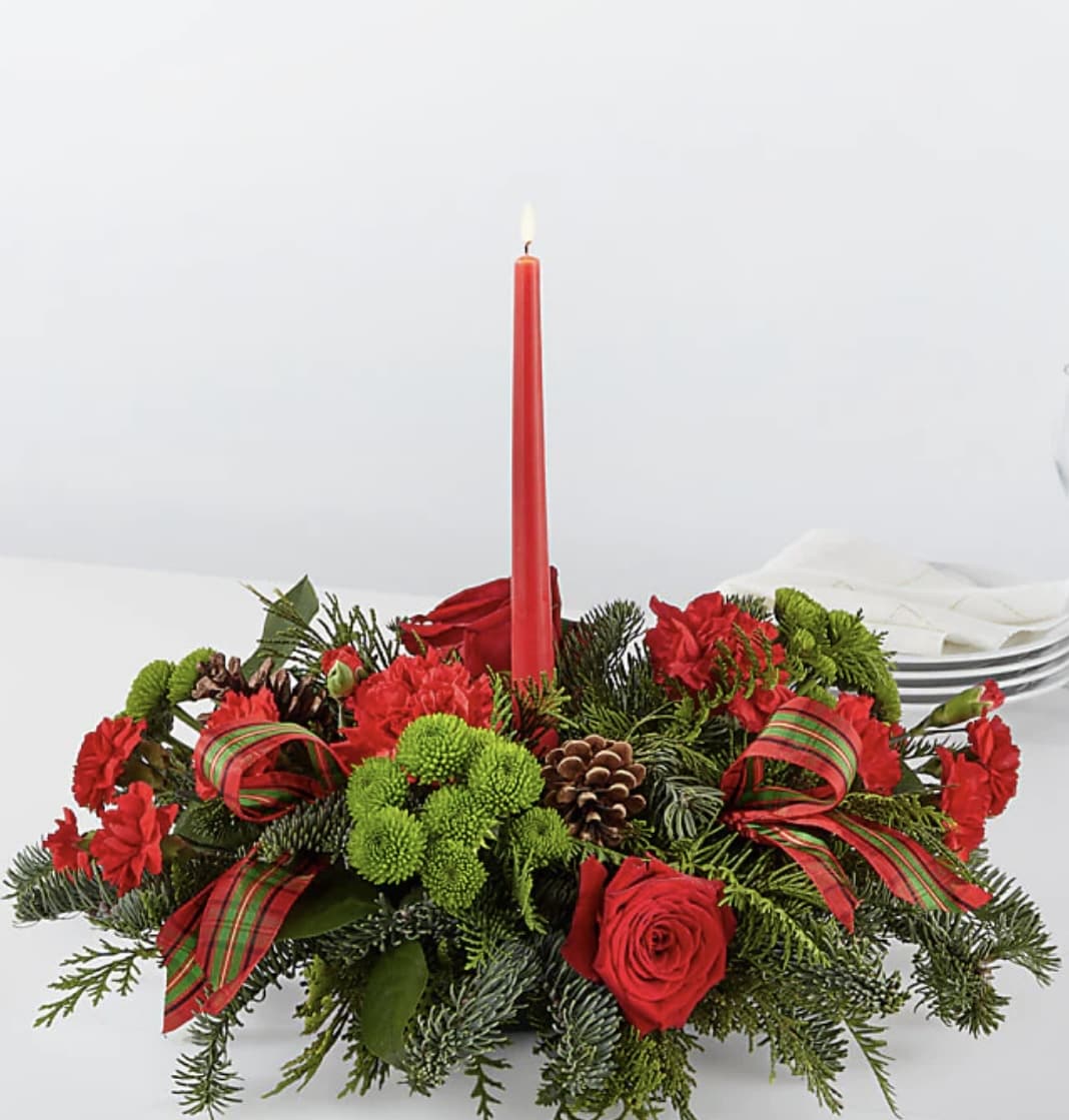By candlelight centerpiece F - Let time fly By the Candlelight centerpiece as new holiday memories are made. What better way to commemorate the joyful homecoming than with classic red roses and lush evergreen accents.