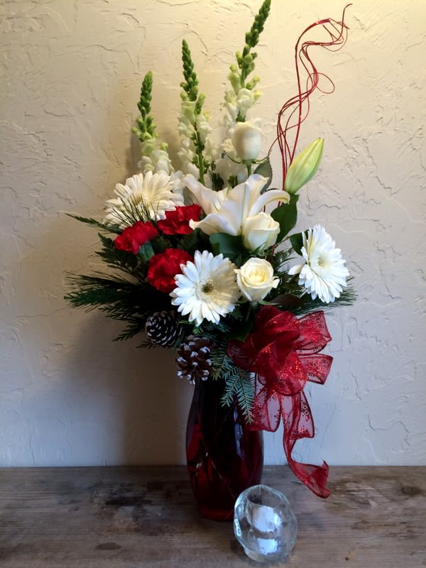 Crickets Christmas Waltz  vase maybe  clear  due  popular demand - Blooming with Christmas cheer and holiday elegance, this stunning yuletide flower bouquet is a gorgeous gift of winter wonder. Red  carnations, and white gerbera and snapdragons  set the back drop for the white Asiatic lilies and white roses  to pop, arranged amongst the holiday greens, perfectly set in a red glass flared vase. A wonderful way to celebrate with your friends, family, and co-workers throughout the festive months ahead!