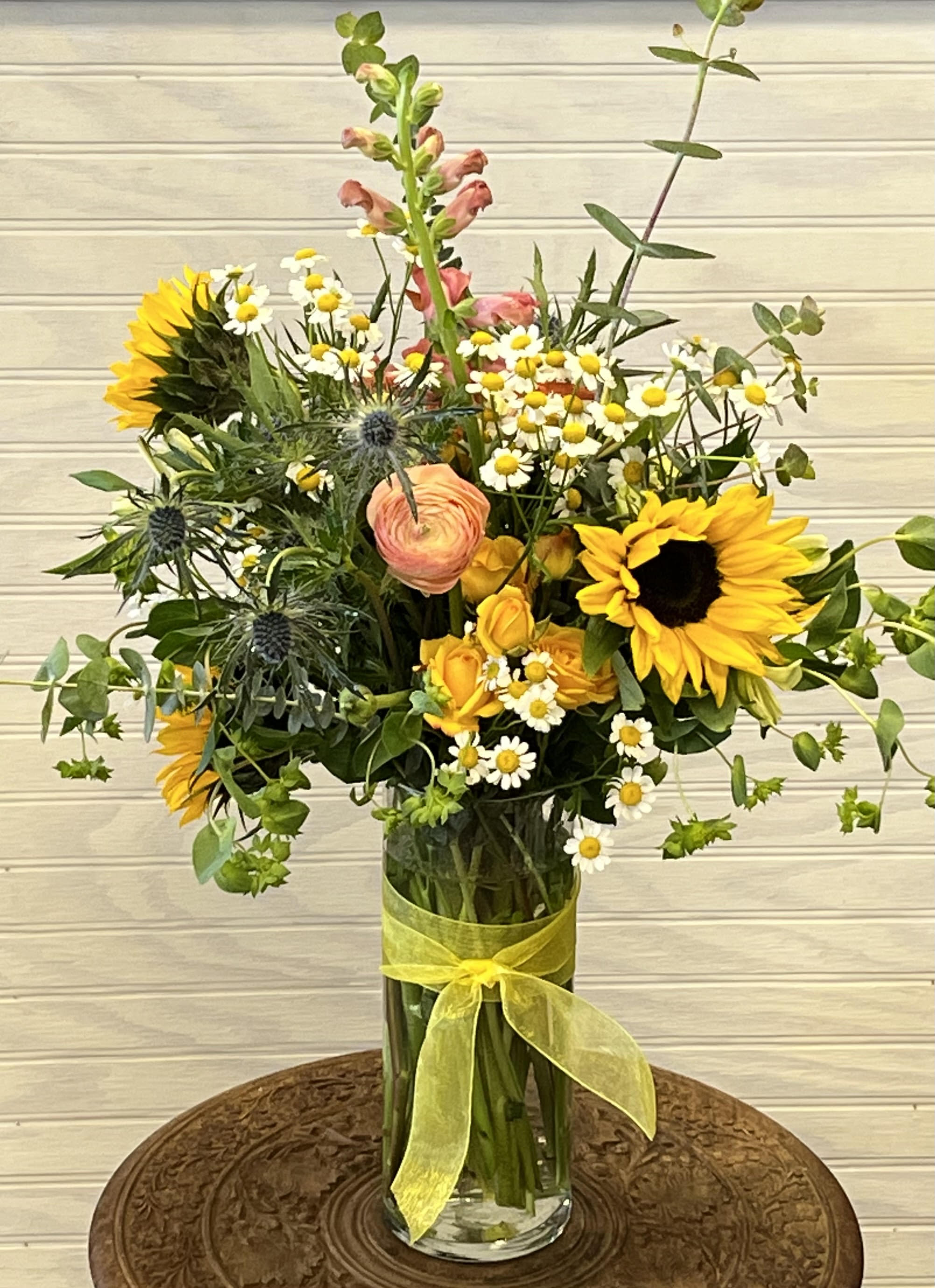 The Gabby - This simplistic arrangement includes sunflowers, thistle, spray roses, ranunculus and snapdragon.
