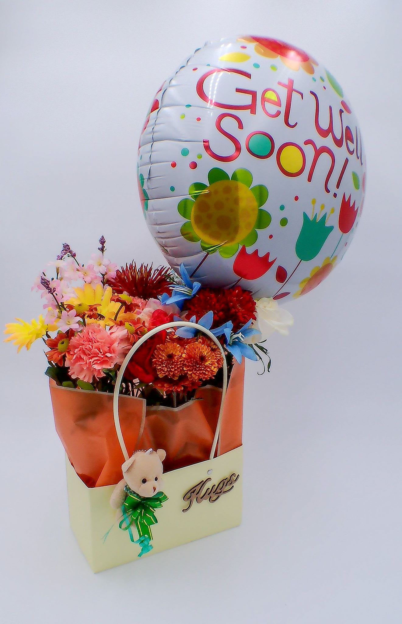&quot;Get Well Soon&quot; Flower Gift Bag with Teddy Bear /Hugs Craft - Mixed Fresh Flowers (14–16 stems): a colorful blend of 8 carnations, 2 chrysanthemums, 2 daisies, and 2 lilies. 18-inch Get Well Soon  Foil Balloon (1 pc) Mini Teddy Bear (11 cm / 6 cm)  Handmade “Hugs” Craft (1) Reusable Gift Bag (32.5cm*22cm*13cm) Total Weight:700 g Ideal for: Hospital visits, Home recovery gifts, Get well soon, Wishes for family, friends, or coworkers, Uplifting someone who needs encouragement.