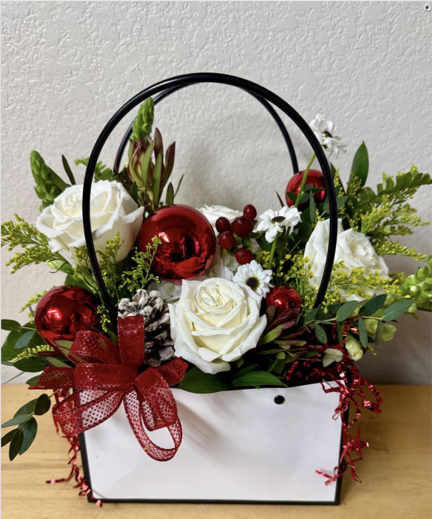 Christmas Floral Bag  - A unique arrangement hand-created by our experienced designers. Please note that every design is custom made and substitution to container and flower types may happen from time to time. Design aspects will always stay the same, but if needed, we will substitute with flowers of equal or greater value to offer you a great floral shopping experience! Our flowers are 100% guaranteed. Please call us with any questions or concerns