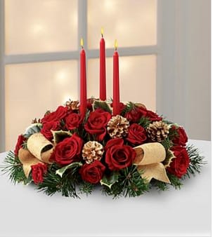The Celebration of the Season™ Centerpiece by FTD® - The Celebration of the Season™ Centerpiece by FTD® is a grand display of holiday elegance. Red roses and spray roses pop against a backdrop of assorted holiday greens and variegated holly that beautifully encircle three red taper candles. Accented with gold pinecones and gold metallic brocade ribbon, this centerpiece creates a warm and enchanting glow to benefit their holiday festivities. BETTER bouquet is approximately 9&quot;H x 18&quot;W. Your purchase includes a complimentary personalized gift message.