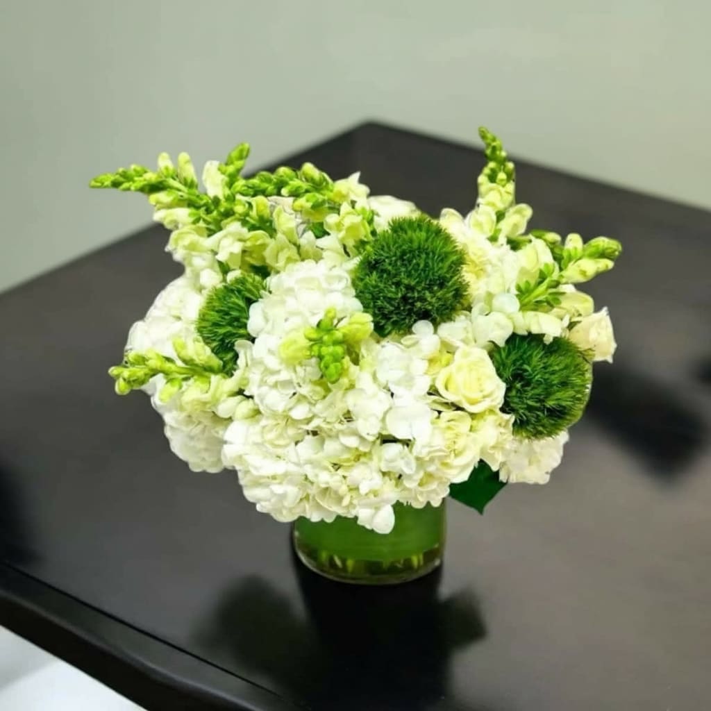 Emerald Medows - Cylinder vase displaying hydrangeas, snap, dragons, spray roses and green dianthus balls.