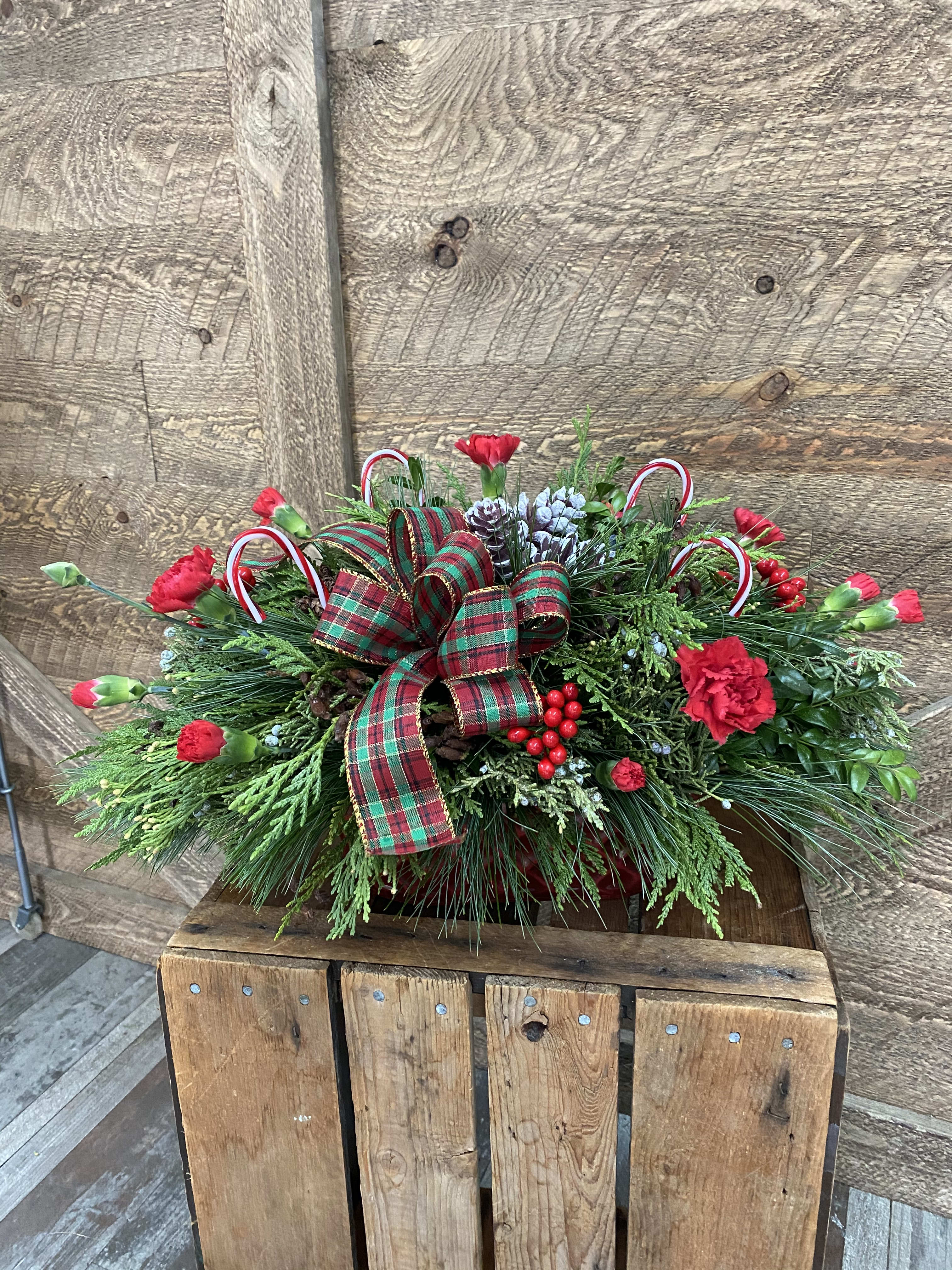 Winter in a container - This arrangement includes mostly long lasting evergreens in an adorable winter container. We then add fresh flowers like mini carnation and berries to complete the winter holiday look. 
