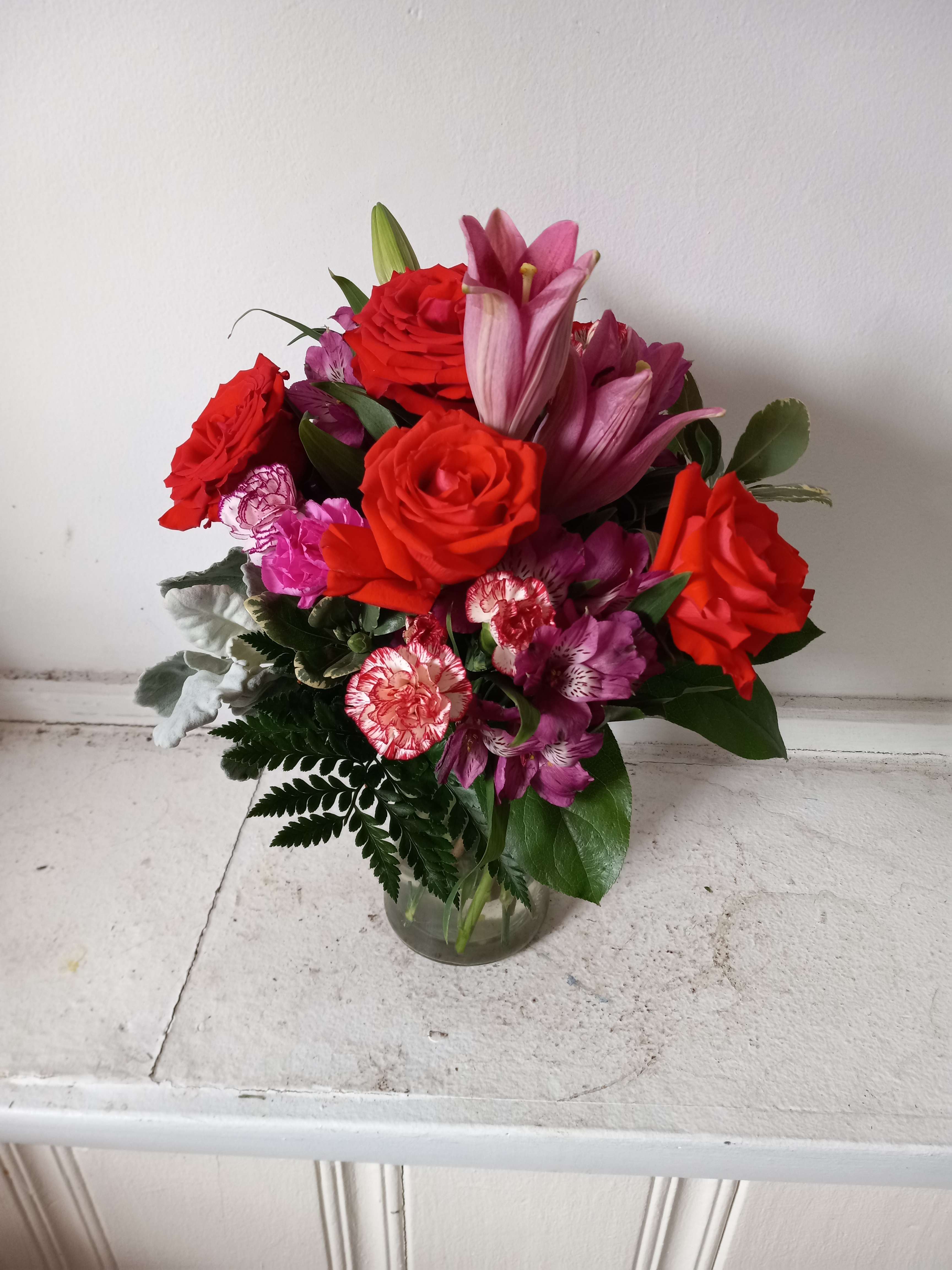 &quot;Teresa&quot; - Beautiful orange roses mixed in with pink lilies, purple/pink alstroemeria and light pink spray carnations in a glas vase 