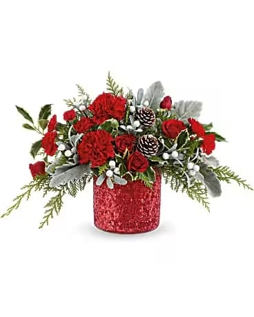 Teleflora's Magical Wish Bouquet - Magical Wish Bouquet is bursting with red flowers and winter greens in a shimmering red vase. A bright and festive gift or centerpiece for Christmas gatherings and seasonal cheer. Magical Wish Bouquet features red spray roses, red carnations, red miniature carnations, dusty miller, cedar, and variegated holly-arranged in a sparkly red vase for festive holiday flair.