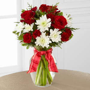 Goodwill and cheer - Red and white are the colors of the season and we have them here in this vase arrangement.   Roses and cushion poms combine with holiday evergreens to make simple yet pretty statement just in time for the holidays