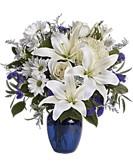 Beautiful Blue  - Brighten the home with the peace and beauty of a bright blue sky. This beautiful bouquet with pure white flowers in a gorgeous blue glass vase. Beautiful blooms such as crème roses, white lilies and alstroemeria along with yellow and white chrysanthemums, eucalyptus, limonium and more are beautifully arranged in a dazzling cobalt blue vase Approximately