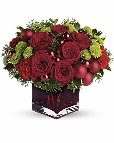 Merry and Bright - This Christmas bouquet stays true to its name! Merry details including red Christmas ornament balls, Douglas fir and variegated holly are mixed with bright green button chrysanthemums in a jolly red cube vase. Lush roses and carnations add to the seasonal splendor. Shiny and matte Christmas balls add a festive touch. Orientation: All-Around
