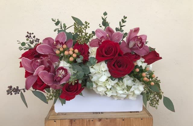 Burgundy Road  - Roses , Orchid blooms , Hydrangeas in white ceramic container 