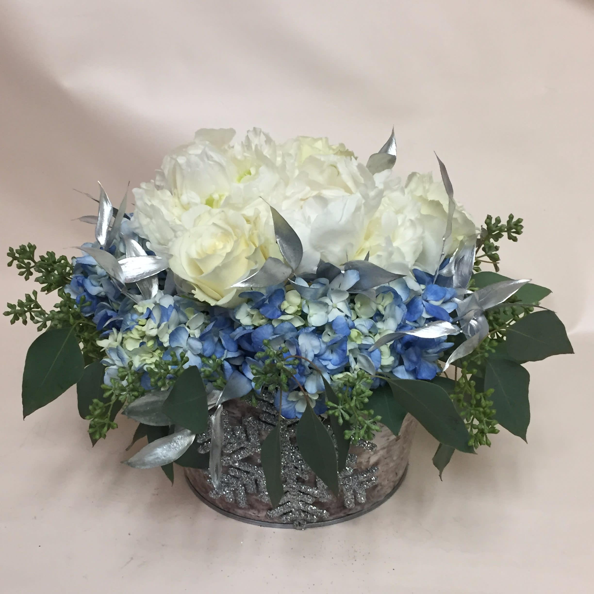 Winter Wishes - Soft shades of blue and white and touches of silver - perfect for any winter holiday.  Traditional centerpiece in a 4&quot; wood cube. BIRCH BOWL IS NO LONGER AVAILABLE. Flower selection from our freshest daily inventory. Shown with premium flowers  - priced at  $85.