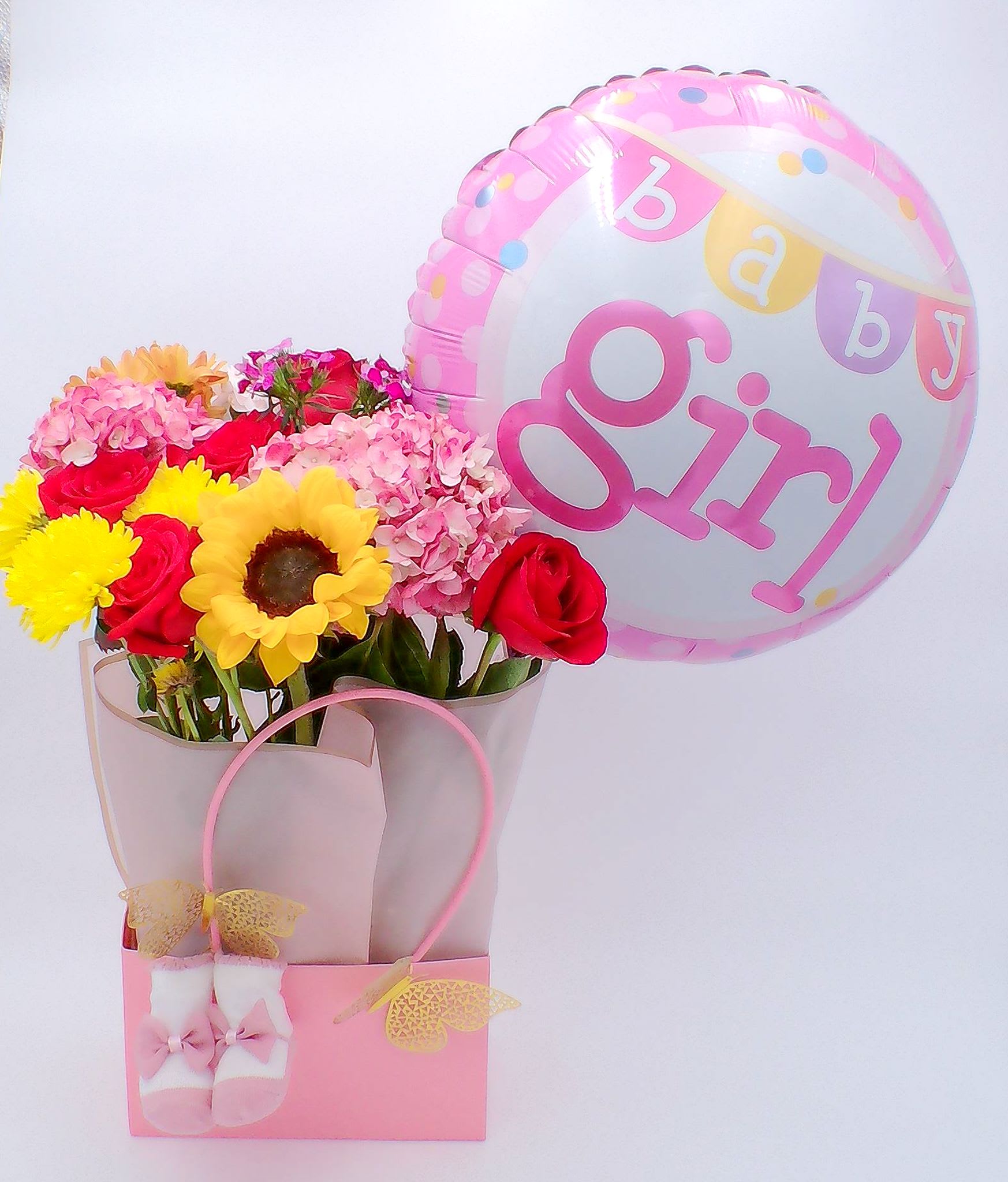 &quot;Welcome Baby Girl” Flower Gift Bag - Mixed Fresh Flowers (14–16 stems): a colorful blend of 4 roses, 4 carnations, 2 amaryllis, 2 daisies, and 2 baby breath. 18-inch “Baby Girl” Foil Balloon (1 pc) Reusable Gift Bag (32.5 cm × 22 cm × 13 cm) Soft pink socks (1pc) Total Weight: Approximately 700 g Ideal for: Baby showers, newborn welcome visits, hospital deliveries, gender reveal celebrations, and thoughtful gifts for new parents celebrating their baby girl.