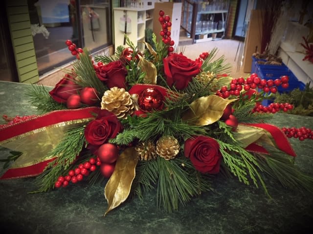 Elegant Red - Oblong centerpiece of roses and winter greens accented with elegant ribbon and shine.