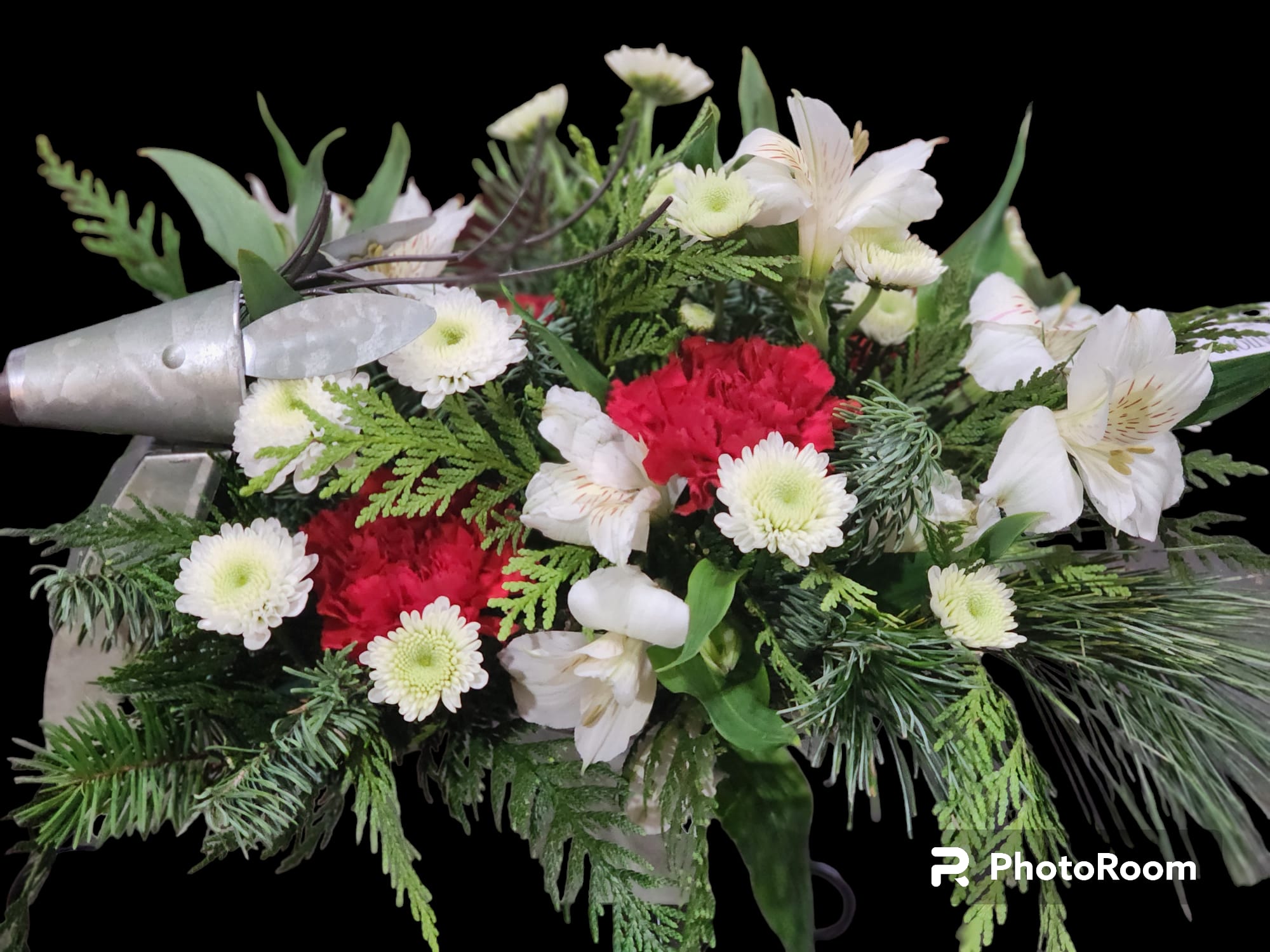 A ride with Rudolph  - This classic metal reindeer shaped sleigh is filled with traditional flowers and seasonal evergreens.  Deluxe and premium include roses and seasonal evergreens 