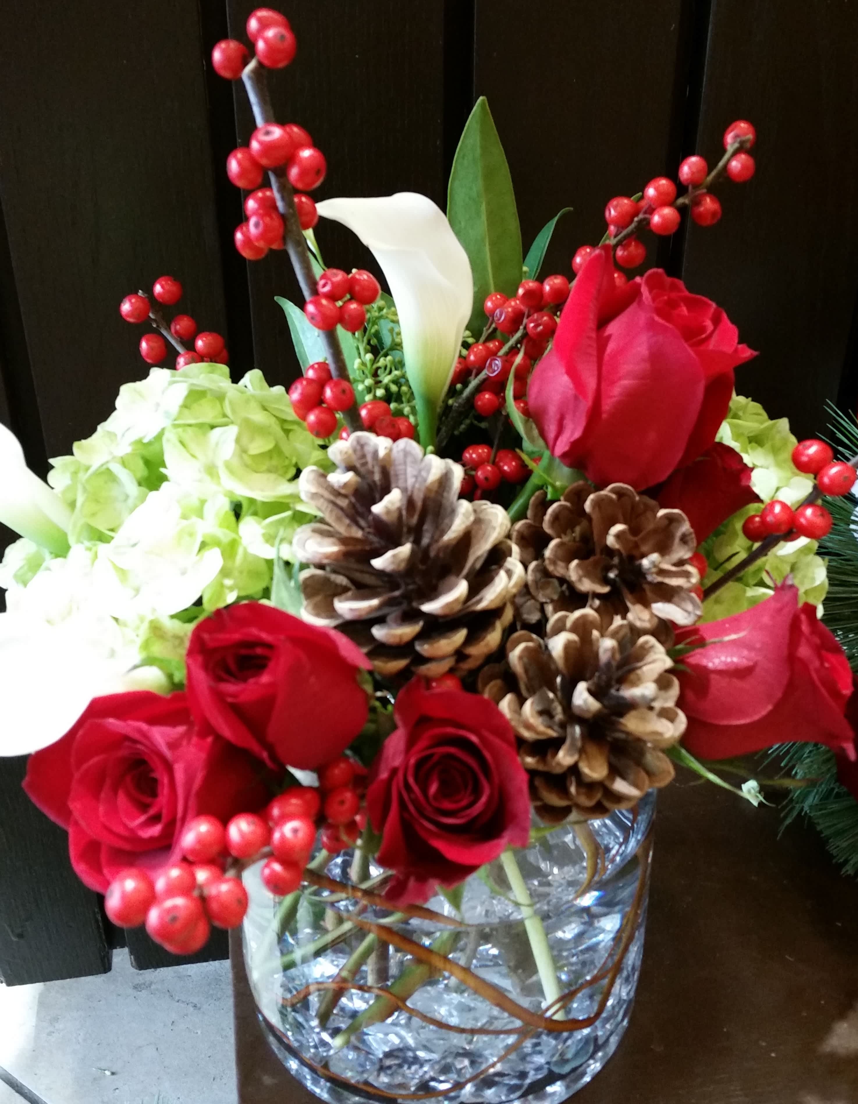 Holidays on Ice - Shimmering and bright, red tulips, white amaryllis or Oriental lily, winter branches and pine are nestled in a clear glass cylinder.  The surprise on the bottom of the cylinder makes this whimsical piece unique.  Realistic looking 'ice cube' crystals line the vase and make the perfect flower cocktail!