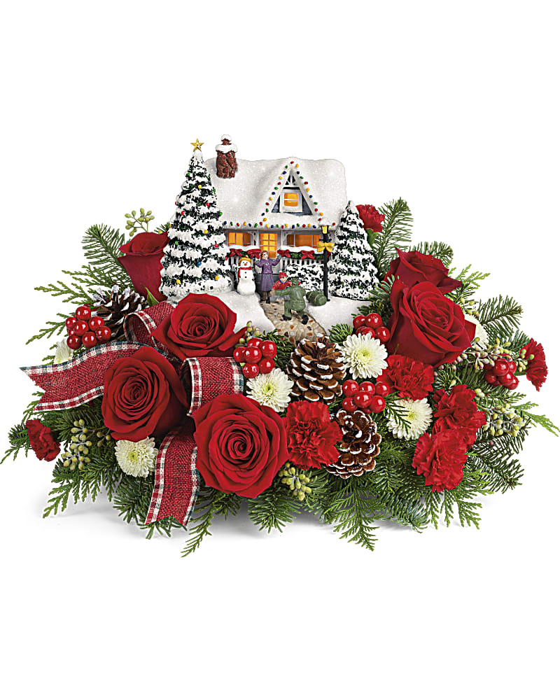 Thomas Kinkade's Hero's Welcome Bouquet (2021) - Home for the holidays! An instant Christmas classic, this lush arrangement of red roses and fresh winter greens accompanies a festively patriotic Thomas Kinkade collectible with light-up windows and hand-painted details. 