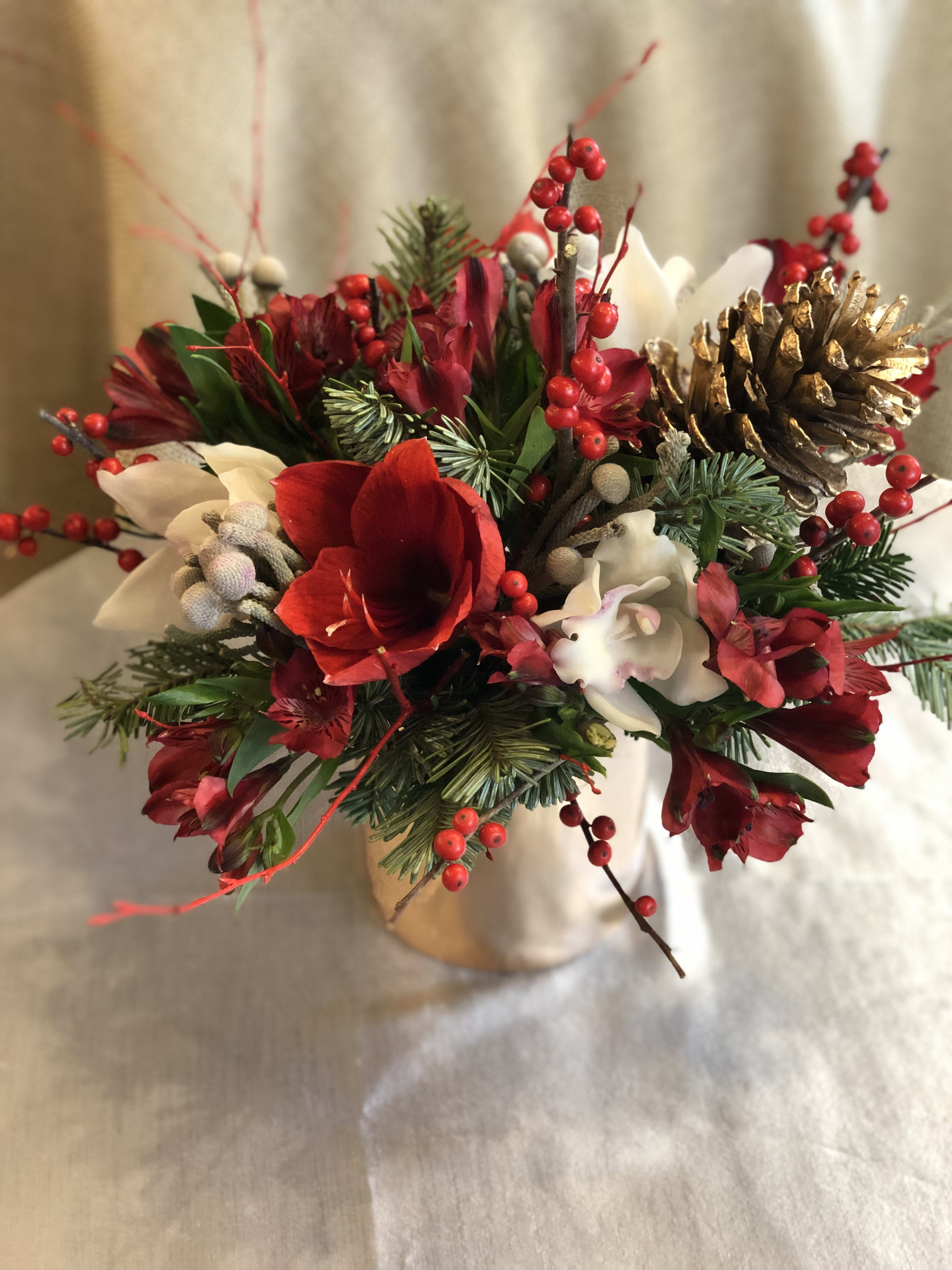 Winterberry Kiss  - A decadent floral display of seasonal red and white toned floral blossoms designed with decorative seasonal pines and arranged in a metallic gold vessel, perfect for any home or office this winter season. 