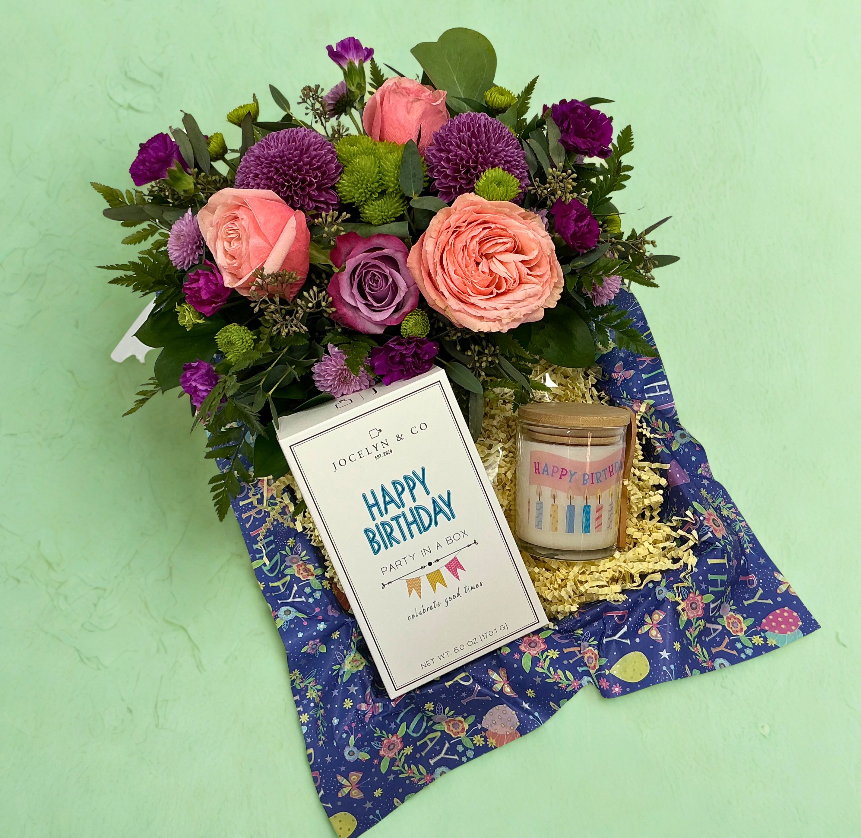Birthday Bloom Box - Celebrate in style with this joyful birthday gift box featuring a fresh floral arrangement bursting with color, a beautifully scented Birthday candle by Charleston Soy Works, and a fun-filled party-in-a-box kit that includes a birthday mug cake &amp; candle, a balloon (not inflated), party blower, confetti, and a mini card. Thoughtful, festive, and ready to delight, it’s everything needed to make their special day unforgettable. Florals vary, please include color preferences in the special instructions.