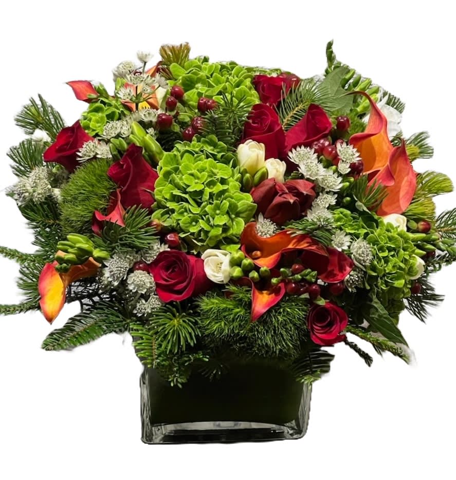 Classic Christmas - The lush seasonal greenery serves as a lively canvas, while the pops of red roses, amaryllis and red calla lilies infuse the arrangement with the spirit of the season, creating a harmonious blend that exudes Christmas charm and sophistication.