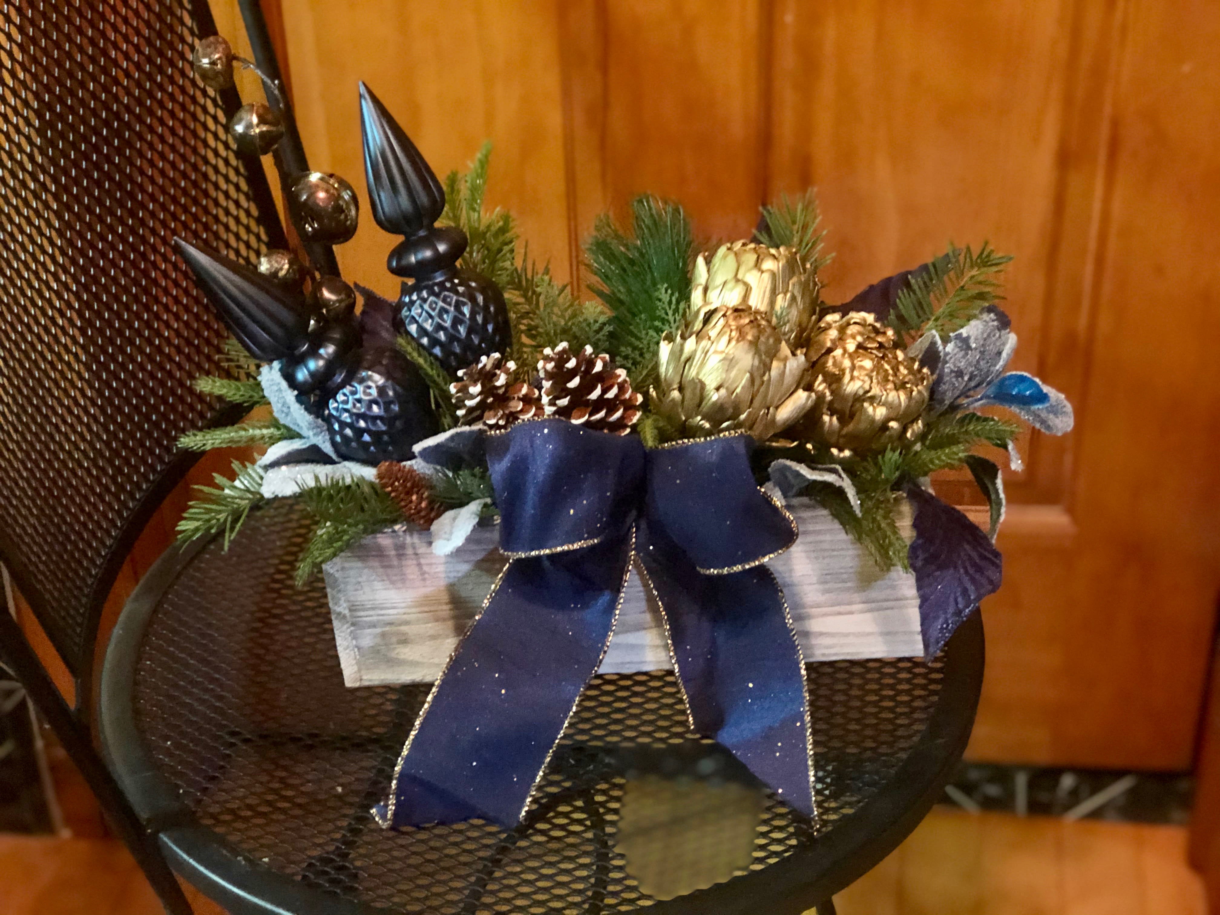 Duchess Royal Blue - Duchess Royal Blue is a custom created permanent silk display for your indoor space. Bring it out every year to amaze and delight. One of a kind creation paired with two unbreakable ornaments, holiday greenery and silk leaf accents nestled into a birch wood box. Displayed with snow covered pinecones, gold artichokes and a ribbon bow.