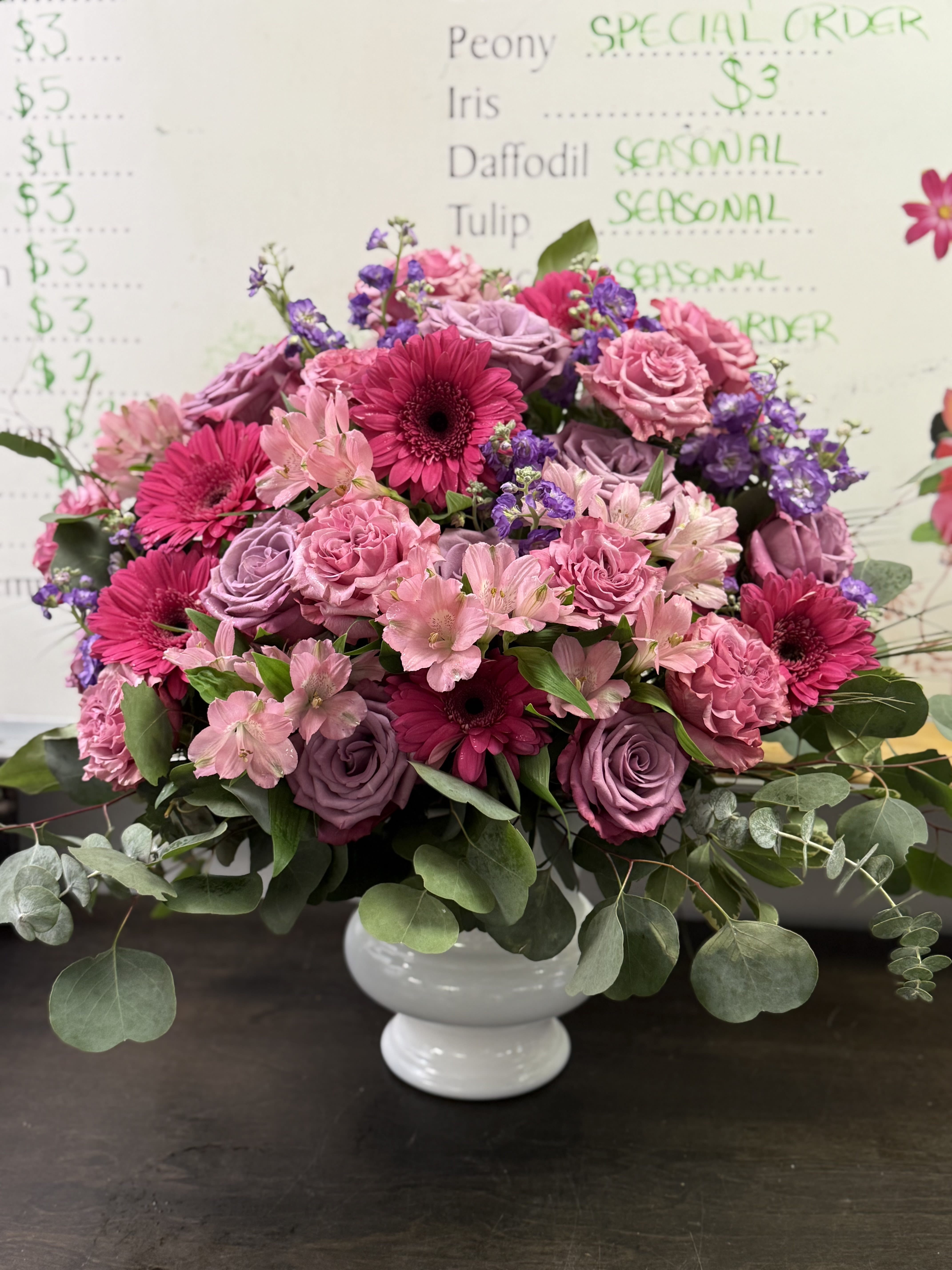 Jewel Toned Sympathy Basket - We arrange hot pinks, lavenders, light pinks, and an assortment of blooms to create this loving sympathy arrangement. Flowers may vary based on our current fresh inventory. 
