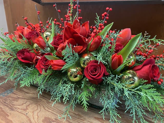 Christmas Centerpiece  - Oblong centerpiece, designed in a 12&quot; long glass vase, filled with winter greens, berries, roses, and festive ornaments for a traditional Christmas feel. 