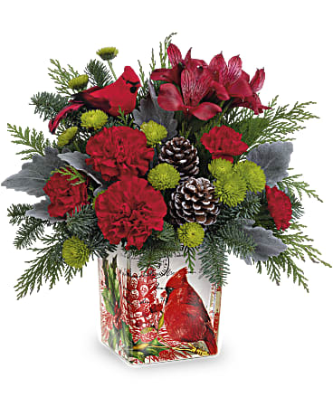Ode To The Cardinal Bouquet - This Christmas cardinal delivers your best wishes for a joyful holiday season with stunning crimson blooms and fresh-from-the-forest greens. The vintage-inspired cube vase doubles as a candleholder!