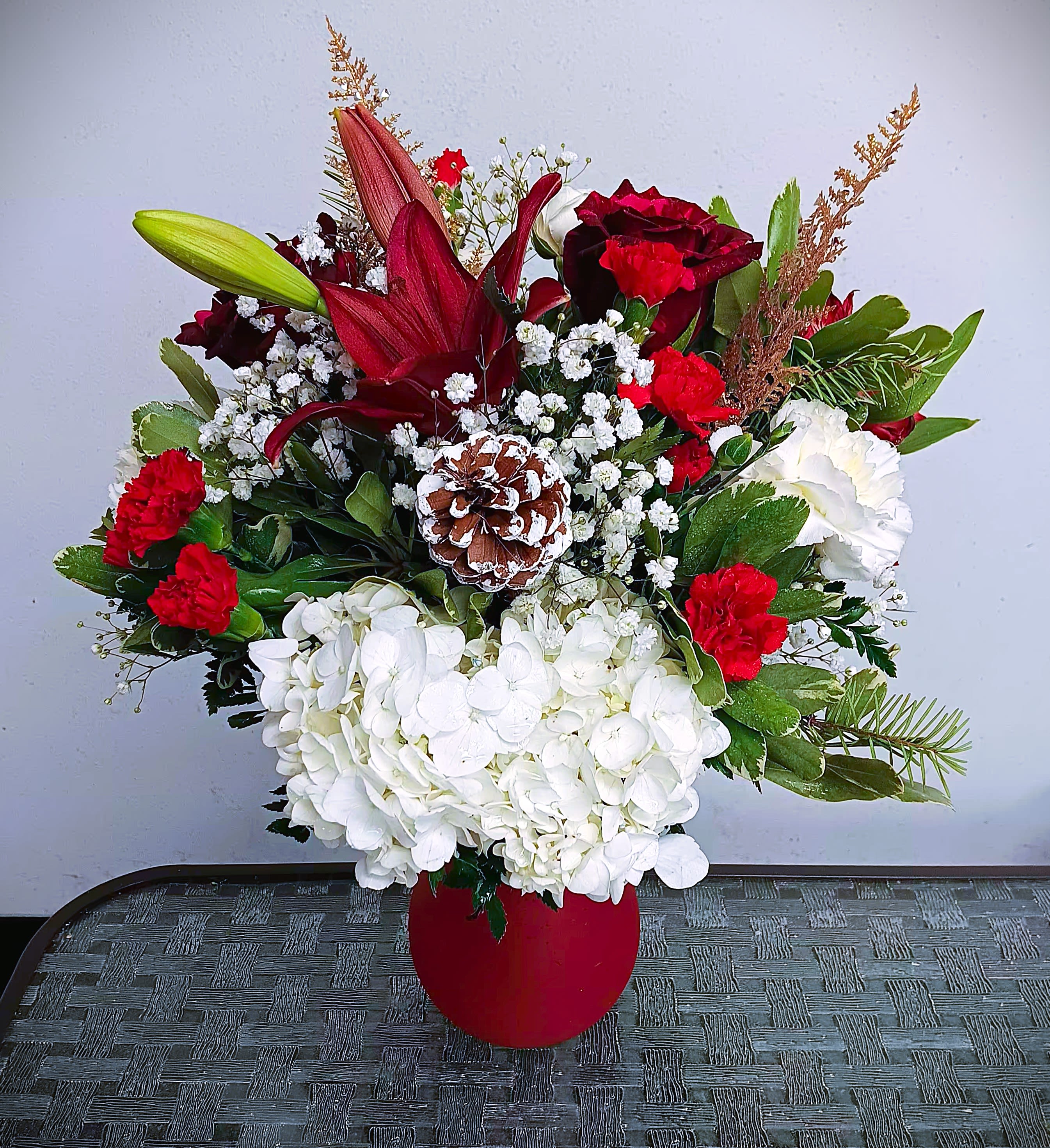I wish you a Merry Christmas. - Fresh floral arrangement with roses, carnations, baby breath, greens, hydrangea, pinecones, and other seasonal products in glass red vase. We deliver!