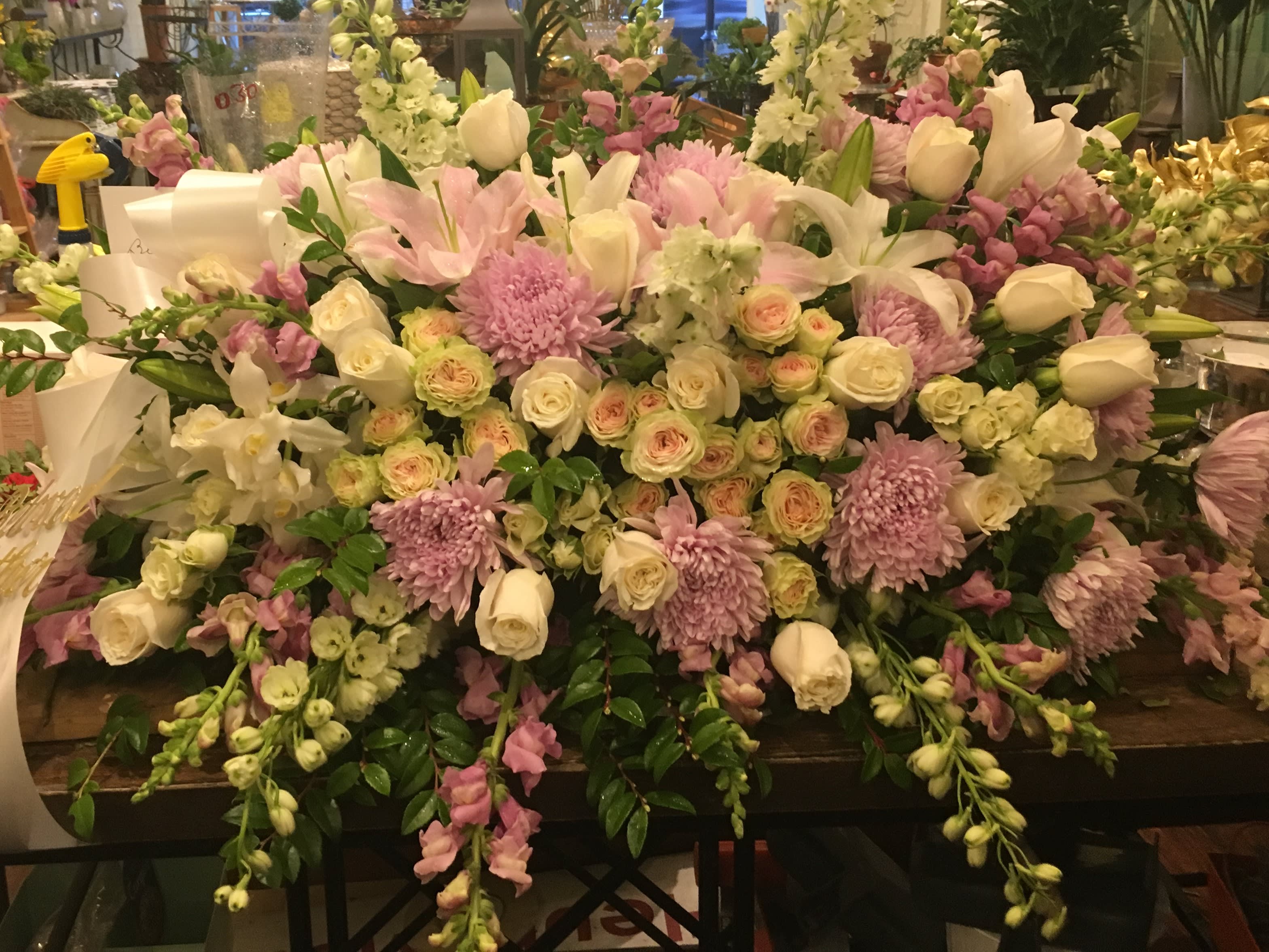 casket spray - Rich white &amp; pink roses are gorgeously arranged amongst lush greens and accented with a satin ribbon to create the ideal adornment for their casket at their final farewell service. Approximately 40&quot;L x 26&quot;W.