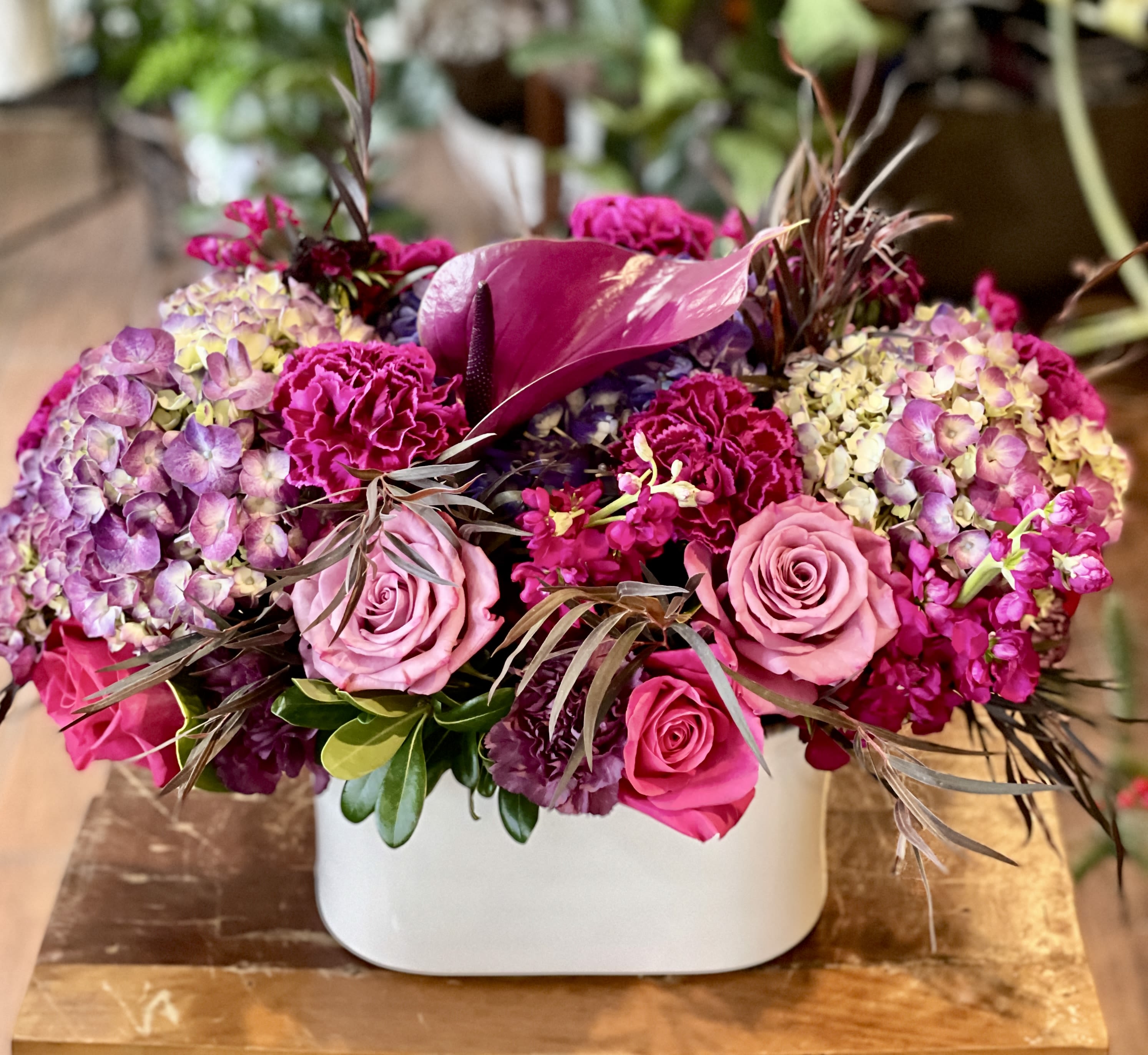 Blair - Deeper and moody shades of pinks and purples in a white ceramic vase. 