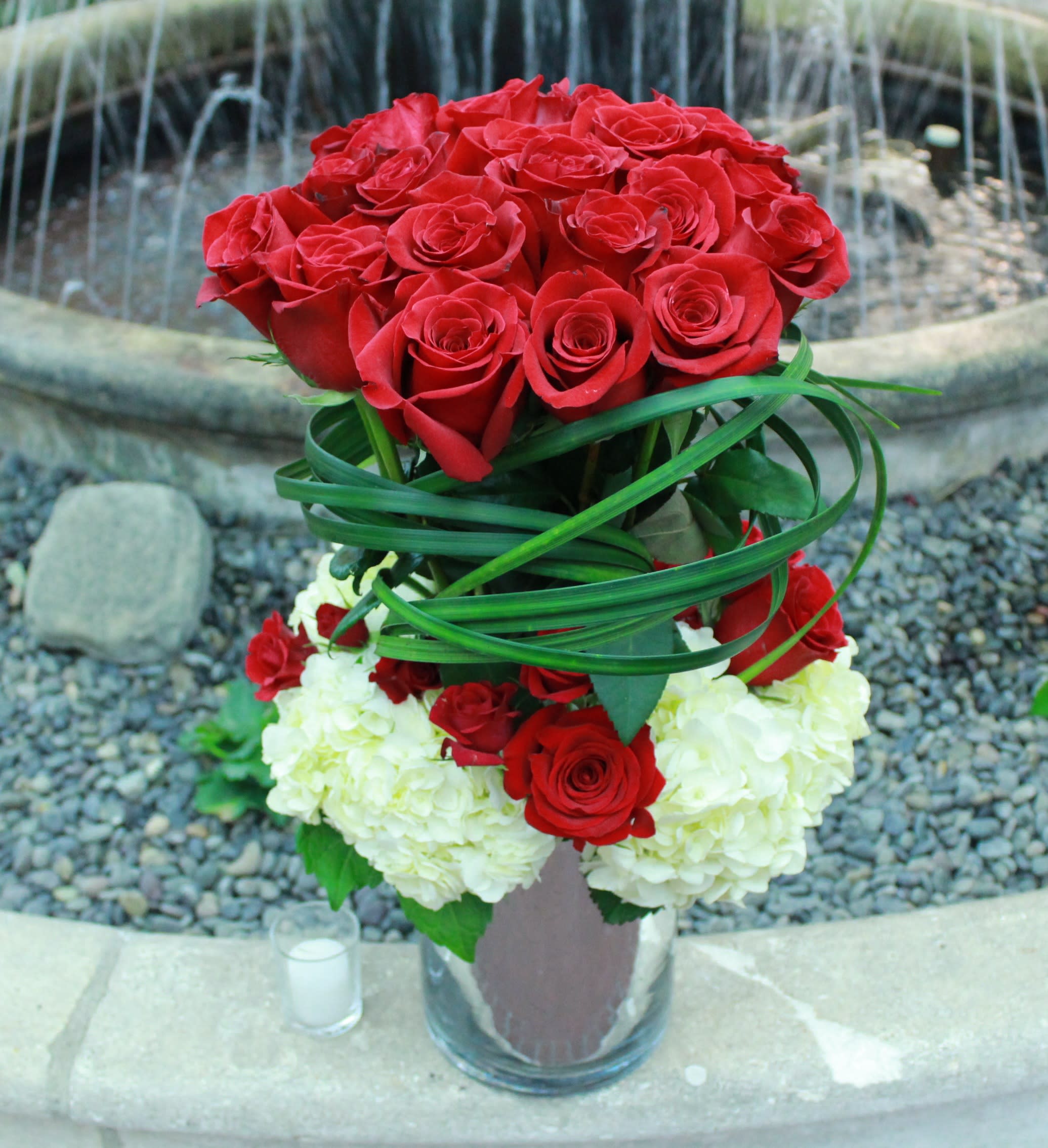 Heavenly Elegance: The Towering Red Roses and Hydrangeas Flower Arrangement - Experience the enchantment of a grand and luxurious floral creation with the &quot;Heavenly Elegance&quot; arrangement, an awe-inspiring tower of red roses and hydrangeas. This arrangement combines the timeless beauty of red roses with the lush allure of hydrangeas, creating a magnificent display that elevates any space to a realm of exquisite elegance and grandeur.  Item: 143  Care Instructions: For the best vase life, change the water every two days.  Varieties and colors of flowers may vary according to season and availability.