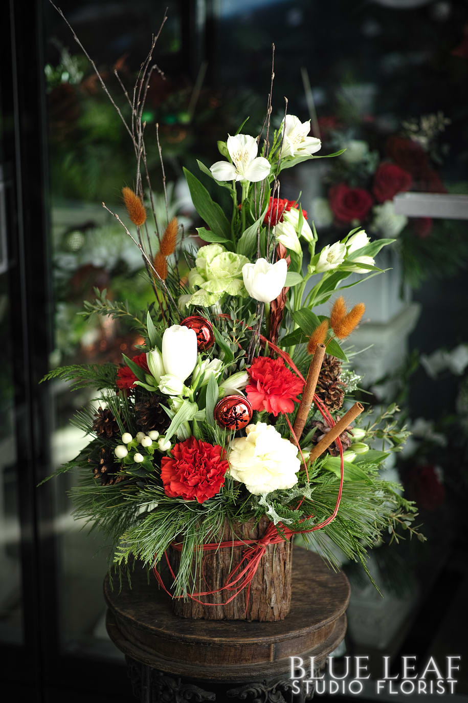 Woodland bouquet - Small arrangement in a redwood container in festive flowers, cinnamon sticks, birch accents.